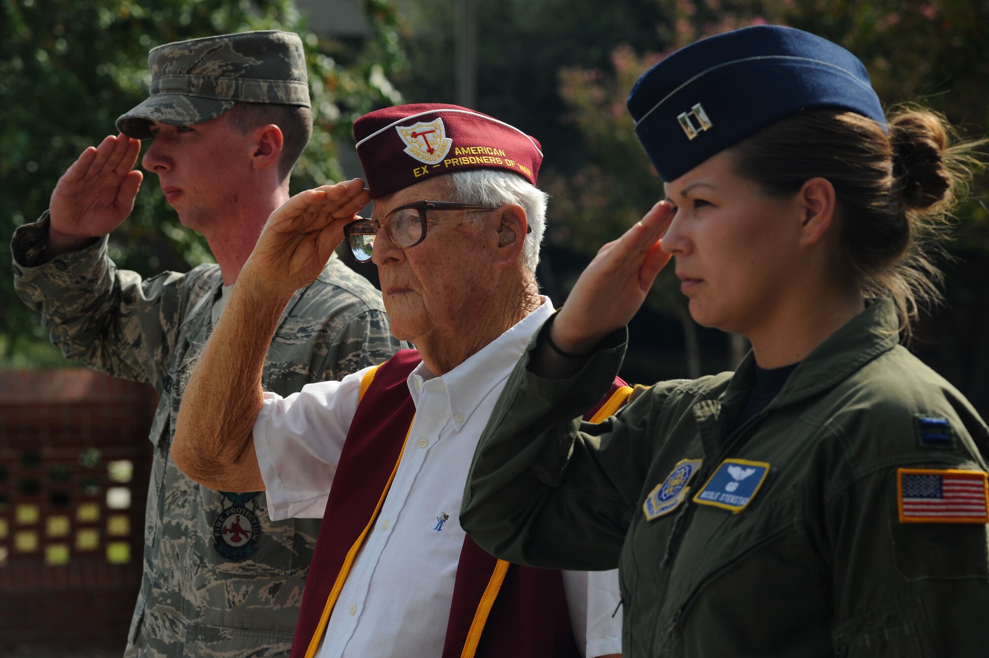 Senior Airman Samuel Siewert, Lt. Col. (Ret.) Ernest Jenkins and Capt. Nicole Stenstad render salutes as the national anthem is played and the flag is lowered during a Prisoner of War/Missing in Action retreat ceremony on Joint Base Charleston, S.C., Sept. 17, 2010. The retreat commenced after the end of a 24-hour, joint-service run, which kept military service flags and the POW/MIA flag in constant motion. Colonel Jenkins, a former POW, was detained in Bath, Germany, during World War II after his B-17 was shot down. He was imprisoned for 17 months. Colonel Jenkins was a bombardier on the B-17 "Stardust," Airman Siewert is a driver operator with the 628th Civil Engineer Squadron and Capt. Stenstad is a C-17 pilot with the 14th Airlift Squadron. (U.S. Air Force photo/Airman 1st Class Lauren Main)