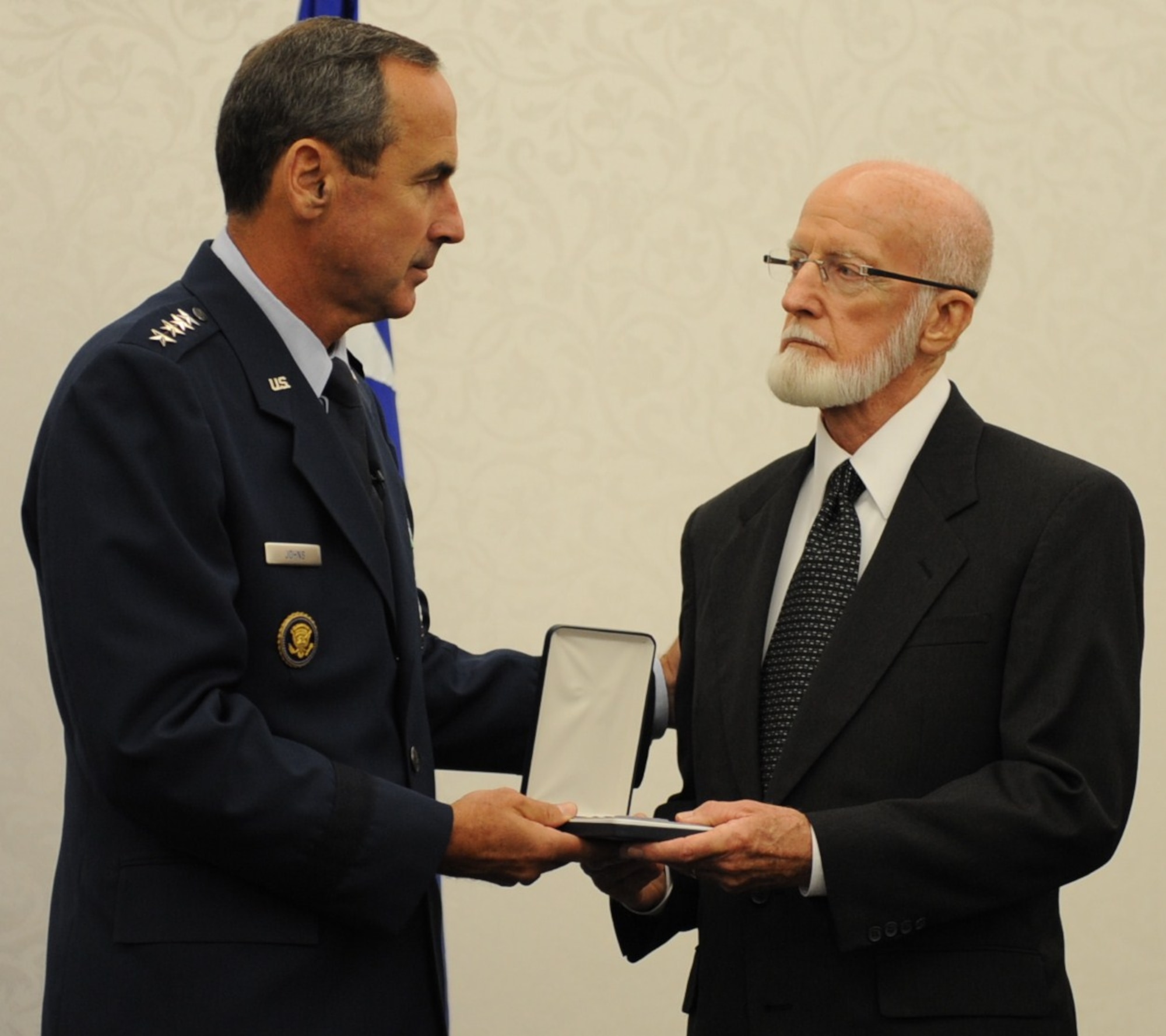 SCOTT AIR FORCE BASE, Ill. -- Gen. Raymond E. Johns Jr., commander of Air Mobility Command, presents Merle Ferguson with his brother’s Purple Heart Sept. 17. Army Private 1st Class John Ferguson, a survivor of the Bataan Death March, died while being held as a POW in the Philippines during WWII. (U.S. Air Force photo/Senior Airman Tristin English)
