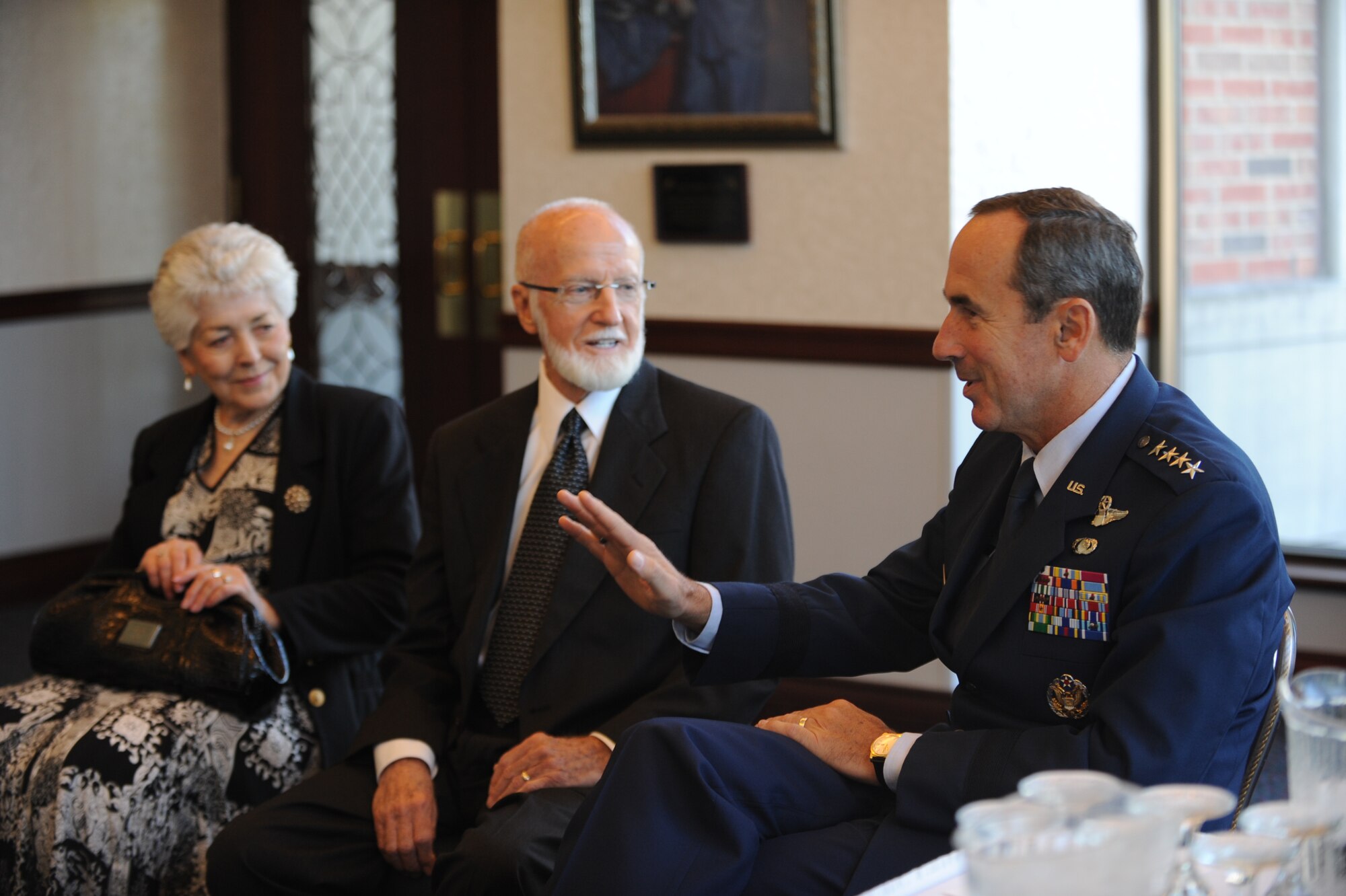 SCOTT AIR FORCE BASE, Ill. -- Gen. Raymond E. Johns Jr., commander of Air Mobility Command, speaks with Merle Ferguson and his wife Kay before presenting the family with their brother’s Purple Heart and Prisoner of War/Missing in Action Medal Sept. 17. Army Private 1st Class John Ferguson, a survivor of the Bataan Death March, died while being held as a POW in the Philippines during WWII. (U.S. Air Force photo/Senior Airman Tristin English)