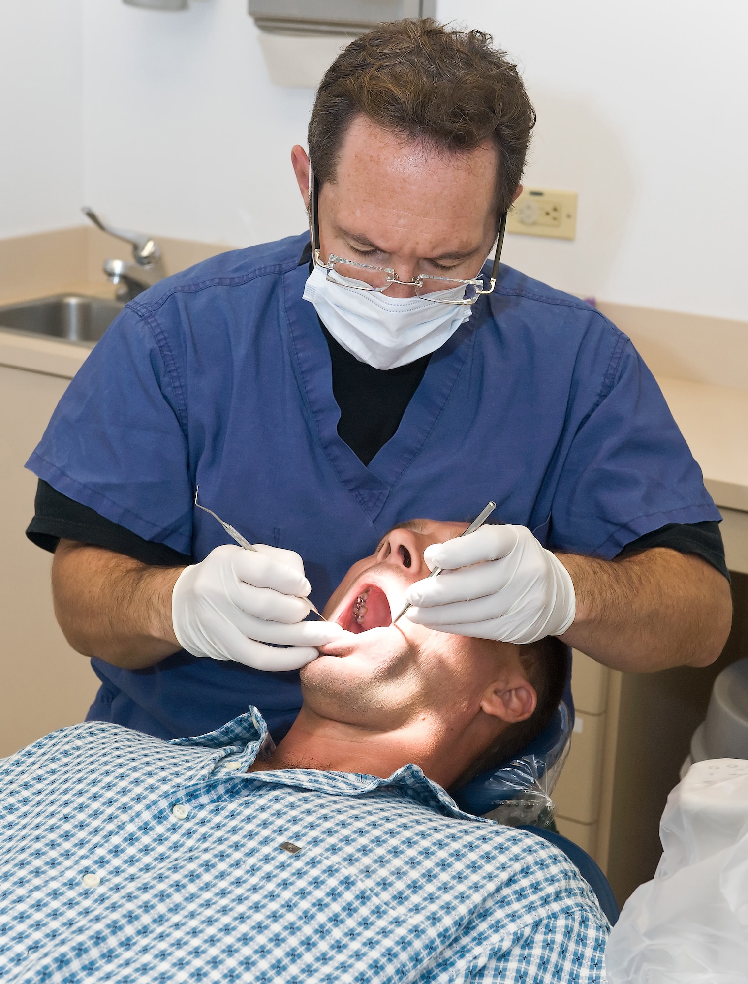 Col. Clifford Zdanowicz, 512th Aerospace Medicine Squadron dentist, performs a dental examination on Tech. Sgt. Arron Daugherty, 512th Maintenance Squadron, at the Dental Clinic here during a Unit Training Assembly. Reservists are required to have a civilian dental examination annually and a military dental examination every third year. (U.S. Air Force photo by Roland Balik/Released)