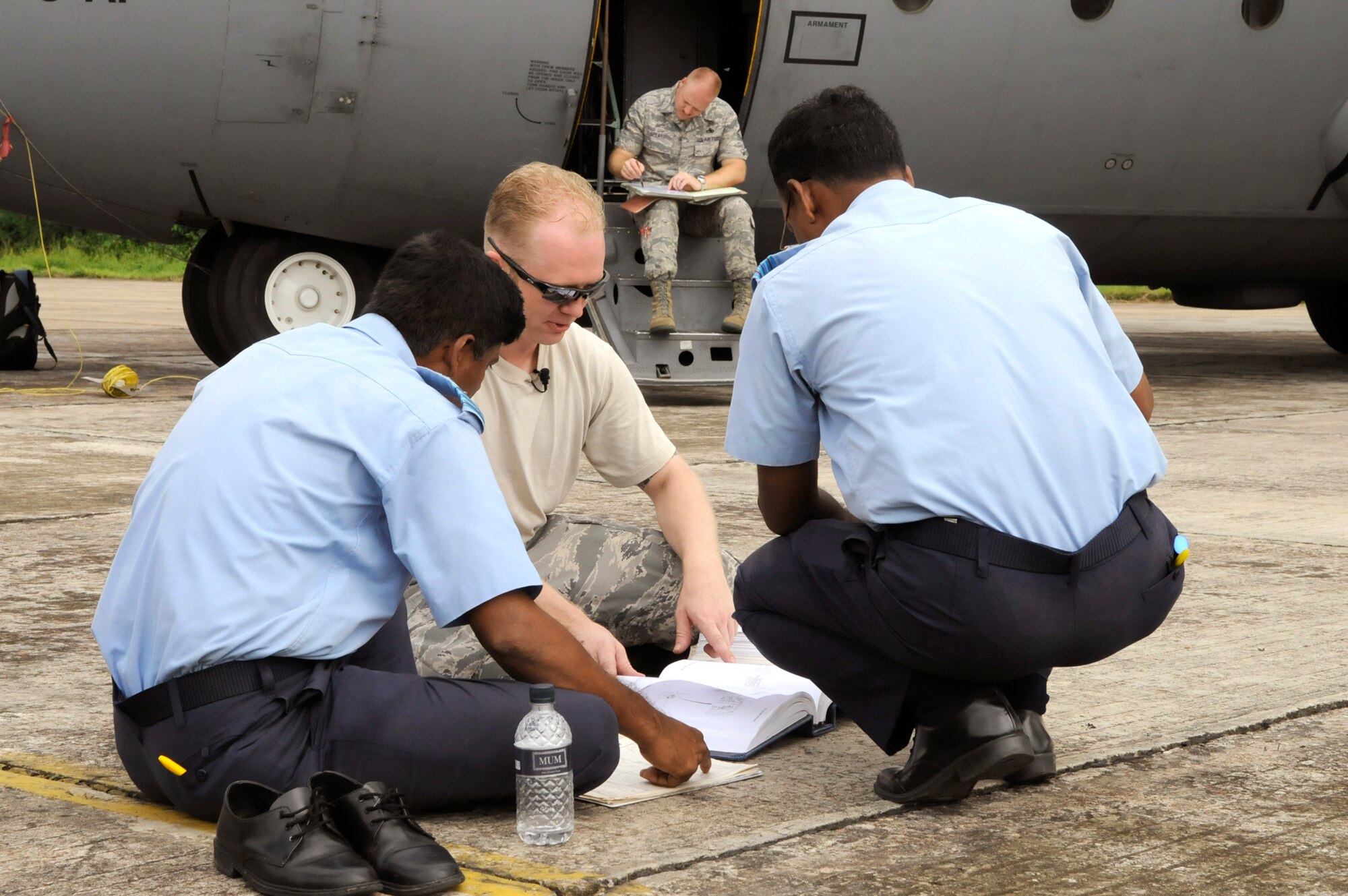 Staff Sgt. Kevin Stubblefield discusses a maintenance problem with Bangladesh air force Military Warrant Officer Abdul Jalil and Military Warrant Officer Golam Faruque, both during exercise Cope South 10 on Sept. 20, 2010, at Kurmitola Air Base, Bangledesh. The bilateral exercise's subject-matter expert exchanges in maintenance, operations and rigging disciplines strengthen the strong and growing partnership between the United States and Bangladesh. Sergeant Stubblefield is an aircraft maintainer from the 374th Maintenance Squadron at Yokota Air Base, Japan. The Bangladesh airmen are aircraft maintainers. (U.S. Air Force photo/Master Sgt. Jeffery Loftin)