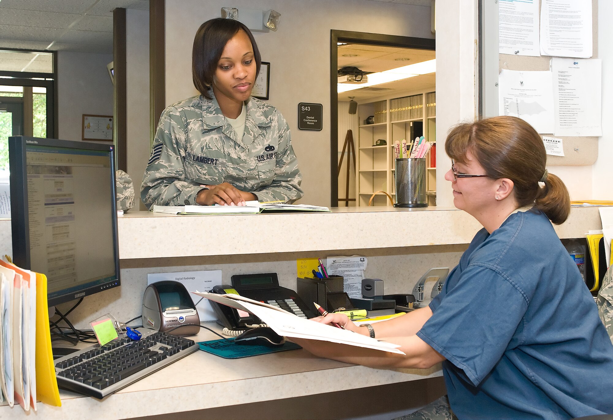 Tech. Sgt. Krystle Lambert, 512th Maintenance Squadron, checks in for her dental appointment with Tech. Sgt. Angela Peacemaker at the 512th Aerospace Medicine Squadron here during a Unit Training Assembly. Reservist are required to have a civilian dental examination annually and a military dental examination every third year. (U.S. Air Force photo by Roland Balik/Released)
