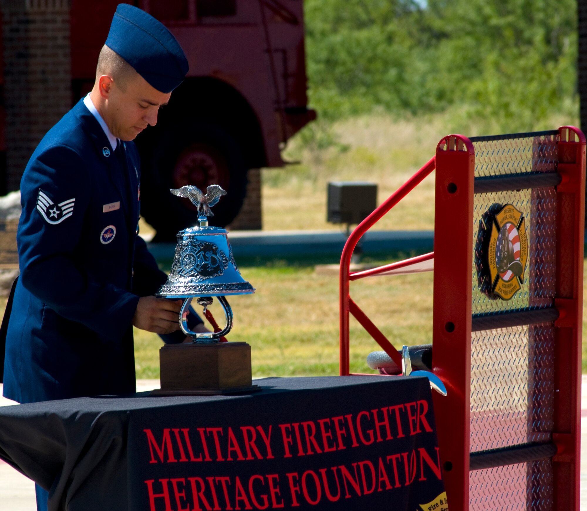 GOODFELLOW AIR FORCE BASE, Texas – Staff Sgt. Joseph Baugh, 312th Training Squadron instructor, makes final adjustments to a display before the start of the Fifth Annual Department of Defense Fallen Firefighter Memorial remembrance Sept. 18. The memorial honors DOD Firefighters who have fallen in the line of duty. (U.S. Air Force photo/ Senior Airman Tong Duong)