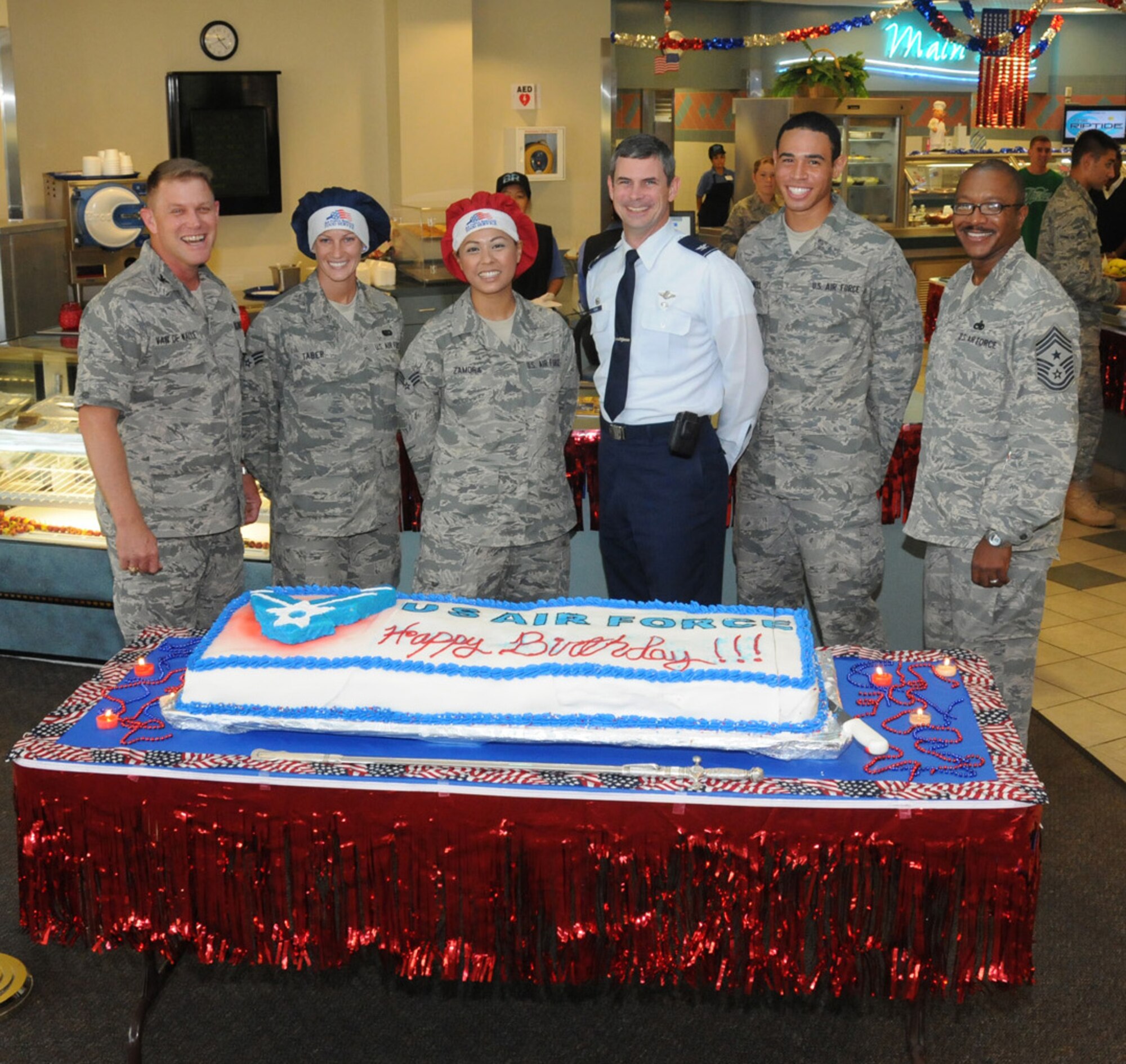 (From left to right) Col. Curt van de Walle, 1st Special Operations Mission Support Group commander, Senior Airman Nicole Taber, 1st Special Operations Force Support Squadron food services specialist, Senior Airman Ashley Zamora, 1st SOFSS food services specialist, Col. Michael Plehn, 1st Special Operations Wing commander, Airman Basic John Powell, tactical air control party trainee, and Chief Master Sgt. Dexter Mitchell, 1st SOW command chief, pose next to a birthday cake marking the Air Force's 63rd birthday during a celebration at the Riptide Dining Facility at Hurlburt Field, Fla., Sept. 17. 2010. Both Airmen Taber and Zamora collectively spent 24 hours baking the three-layer red velvet and white marble cake complete with fondant and almond paste icing. (Courtesy photo by Barbara Fuller) (RELEASED)