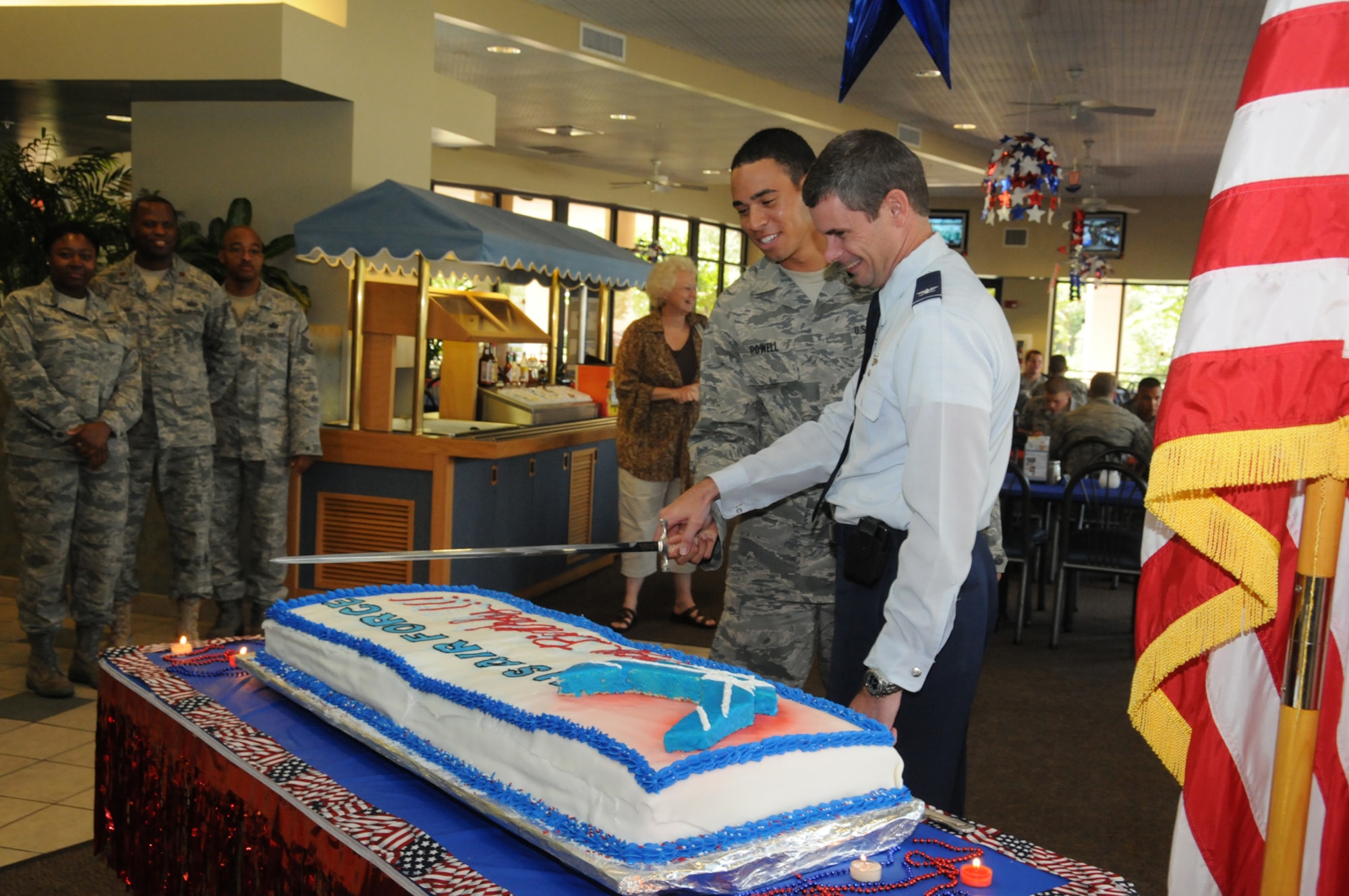 Col. Michael Plehn, 1st Special Operations Wing commander, and Airman Basic John Powell, tactical air control party trainee, use a ceremonial sword to cut the first slice of a birthday cake marking the Air Force's 63rd birthday during a celebration at the Riptide Dining Facility at Hurlburt Field, Fla., Sept. 17. 2010. Both Colonel Plehn and Airman Powell participated in a military tradition in which the most senior and most junior Airmen serve the first slice of cake together. (Courtesy photo by Barbara Fuller) (RELEASED)
