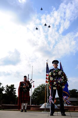 SEYMOUR JOHNSON AIR FORCE BASE, N.C. – Staff Sgt. Jeffery Simmons stands watch over a Prisoner of War – Missing in Action memorial wreath during the 4th Fighter Wing POW/MIA Recognition Ceremony here Sept. 17, 2010. In the background, retired Lt. Col. Norm Taflinger plays the bagpipes as a missing man formation flies overhead.  The first day honoring POW/MIAs was recognized July 18, 1979, with a flyover performed by the 1st Tactical Squadron from Langley AFB, Va. (U.S. Air Force photo/ Senior Airman Mackenzie Lang)