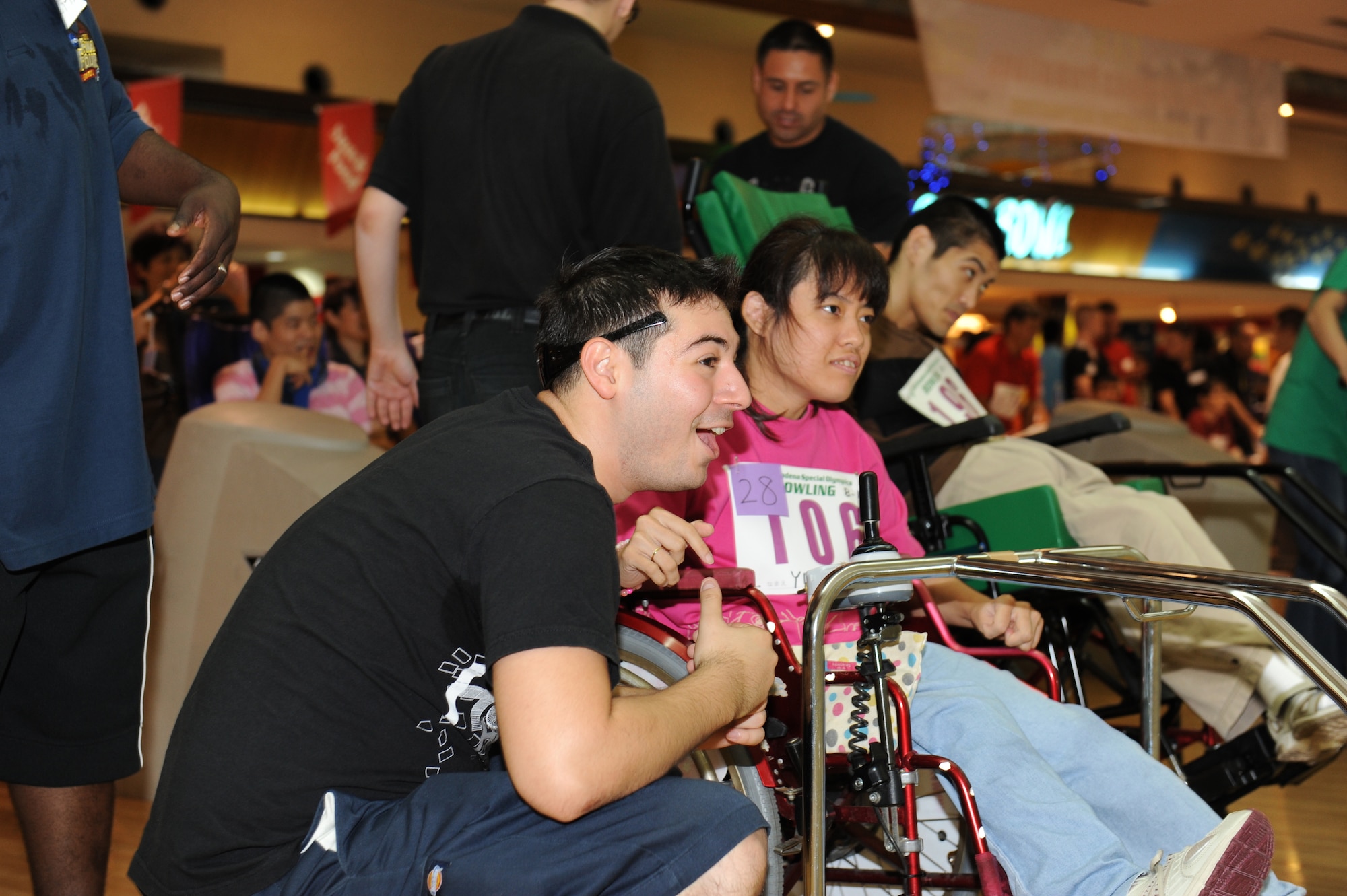Airman 1st Class Justen Rodriguez, 18 Logistics Readiness Squadron fuels technician, assists Yukari Miyazato at the Kadena Special Olympics Bowling event in Mihama, Okinawa, September 18, 2010. The event, attended by more than 300 athletes, volunteers and interpreters, was one of many events leading up to the 11th Annual Kadena Special Olympics, which will be held at Kadena Air Base in November. (U.S. Air Force Photo/Tech Sgt. Jason W. Edwards)