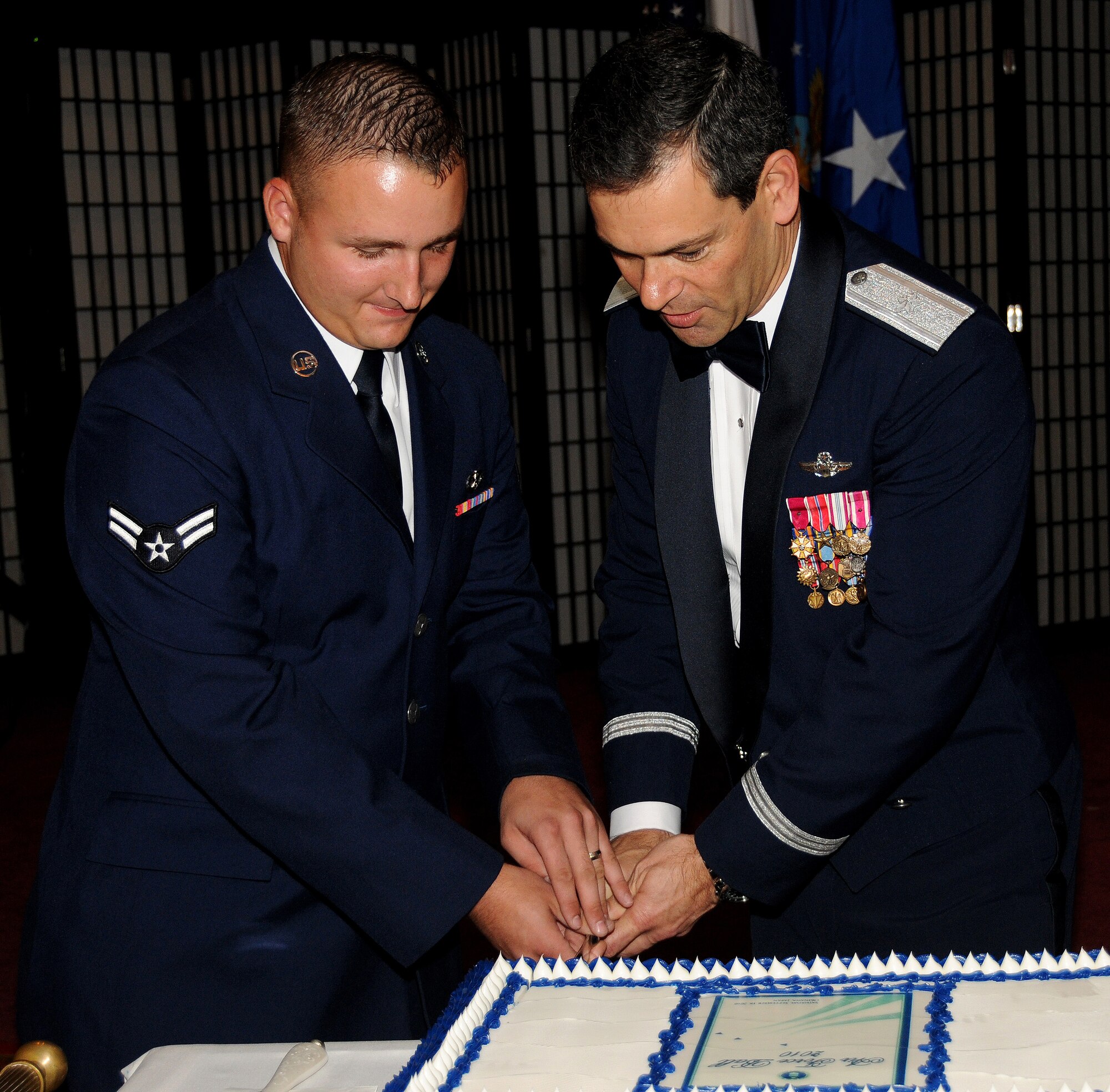 Airman 1st Class Justin Withers, the most junior Airman at the Air Force Ball, along with Brig. Gen. Ken Wilsbach, the 18th Wing commander cuts the ceremonial Air Force birthday cake at the Officers Club Sep.18. The 18th Wing celebrated the Air Force's 63rd birthday in unprecedented fashion by hosting two events simultaneously at the Rocker Non-Commissioned Officer's Club and the Kadena Officer's Club. (U.S. Air Force photo/Airman 1st Class Jarvie Z. Wallace)