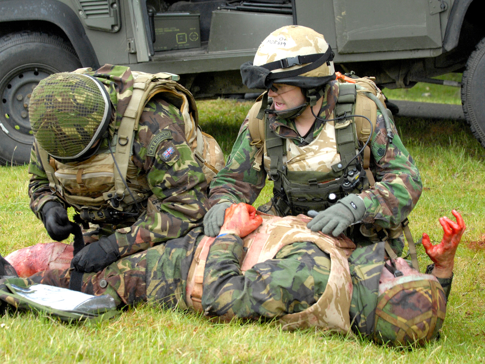 A pair of Royal Air Force Regiment infantry medics from RAF Honington, Norfolk, England, apply a tourniquet to a 'wounded' patient during an exercise combat scenario. In the madness following a roadside bomb or even a traffic accident, if any one person on an infantry team must remain focused, it's the medic, said RAF Sgt. Chris Perrio-Stone, 15 Squadron combat medic trainer. (Royal Air Force Photo)