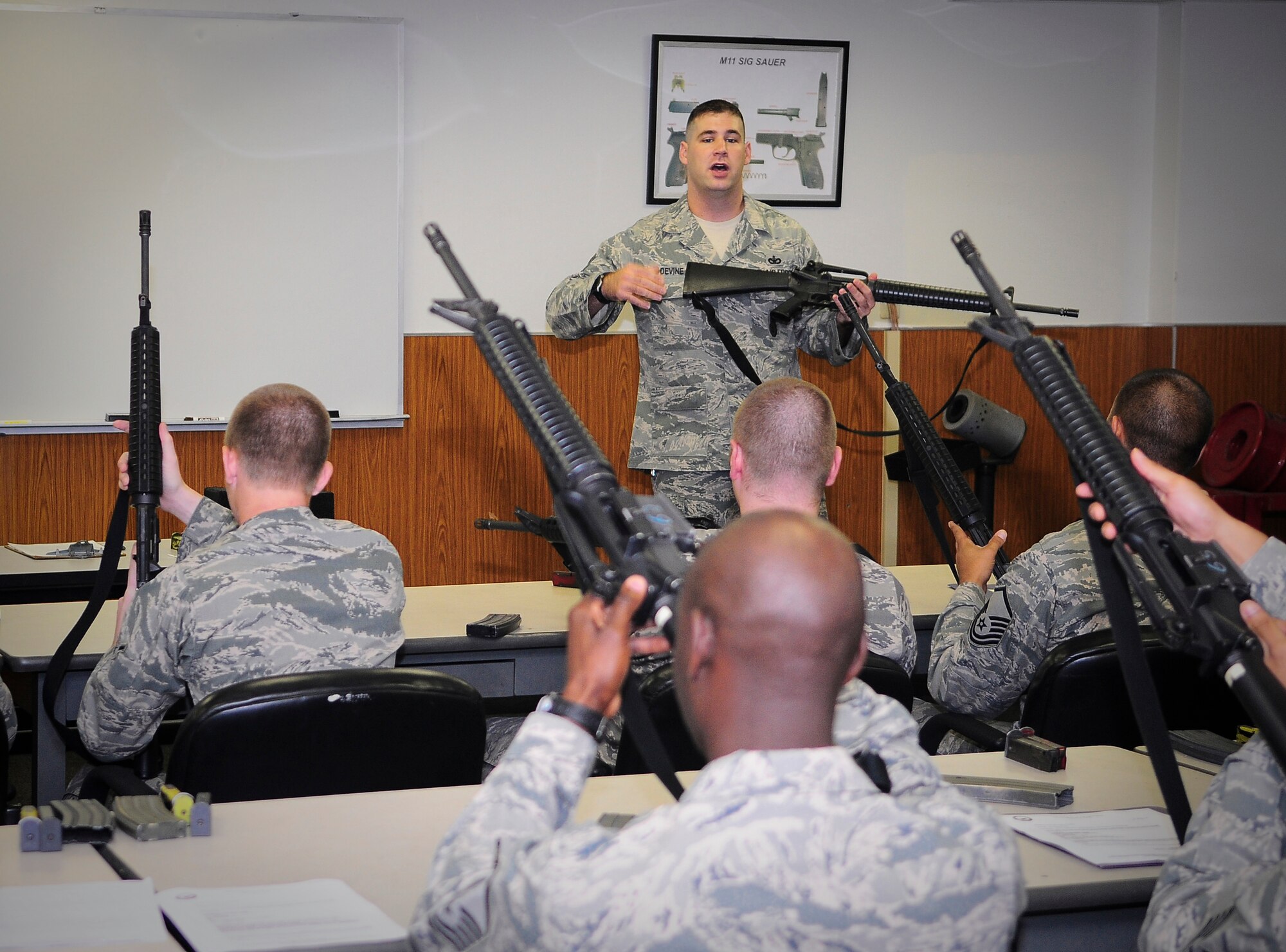 YOKOTA AIR BASE, Japan -- Staff Sgt. John Devine, 374th Security Forces Squadron Combat Arms Instructor, provides information on topics such as the use of force and the fundamentals, characteristics and nomenclature of the M-16 here Sept. 20.  Sergeant Divine gives this information to students during weapons qualification course designed to help airmen maintain readiness standards. (U.S. Air Force photo by Staff Sgt. Stacy Moless) 