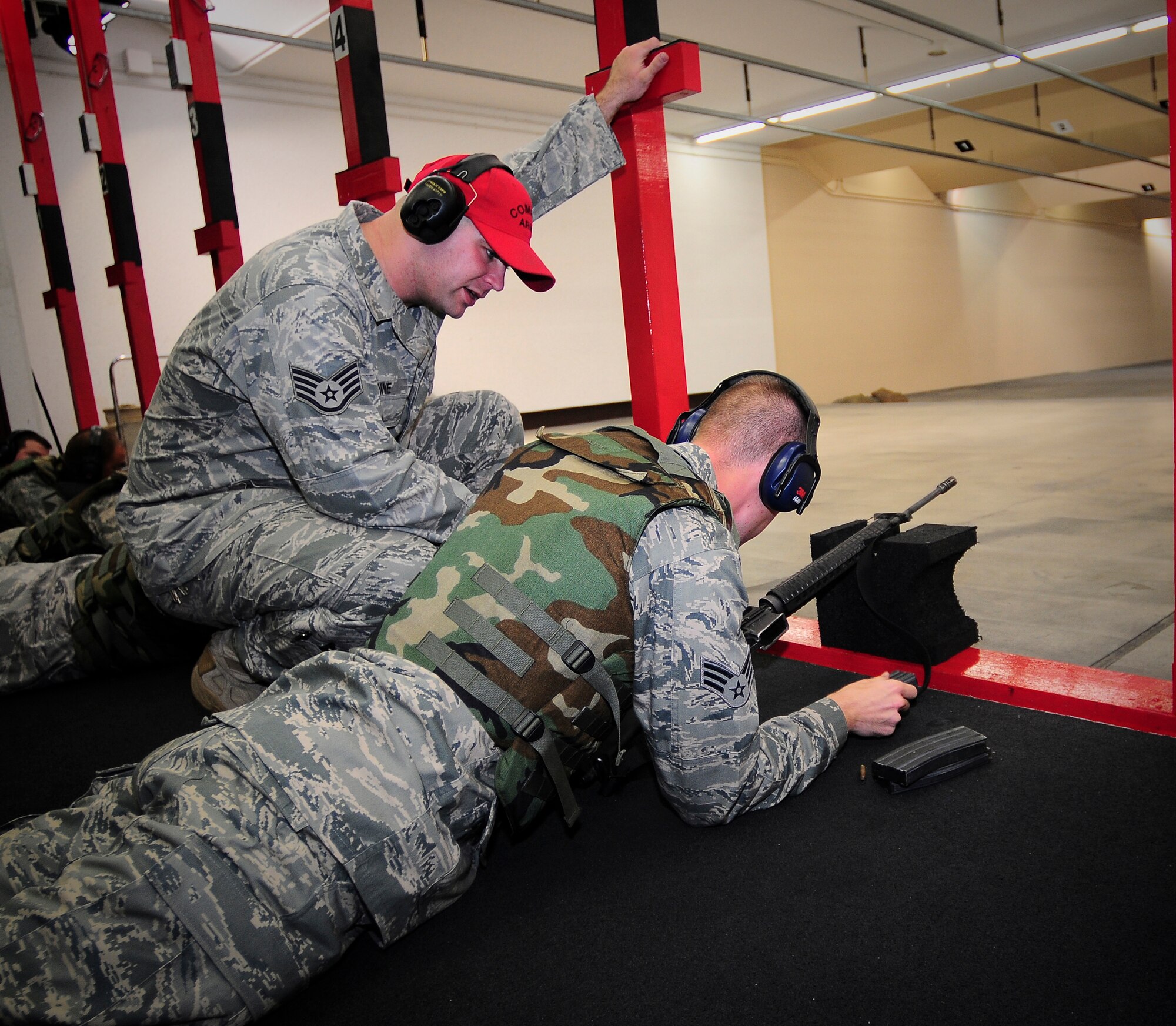 YOKOTA AIR BASE, Japan -- Staff Sgt. John Devine, 374th Security Forces Squadron Combat Arms Instructor,  helps Senior Airman Eric Hunsaker 374th Force Support Squadron, fix a jam in his M-16 during a training class here Sept. 20. Airmen attended the weapons qualification course to maintain readiness standards. ( U.S. air Force photo by Staff Sgt. Stacy Moless) 
