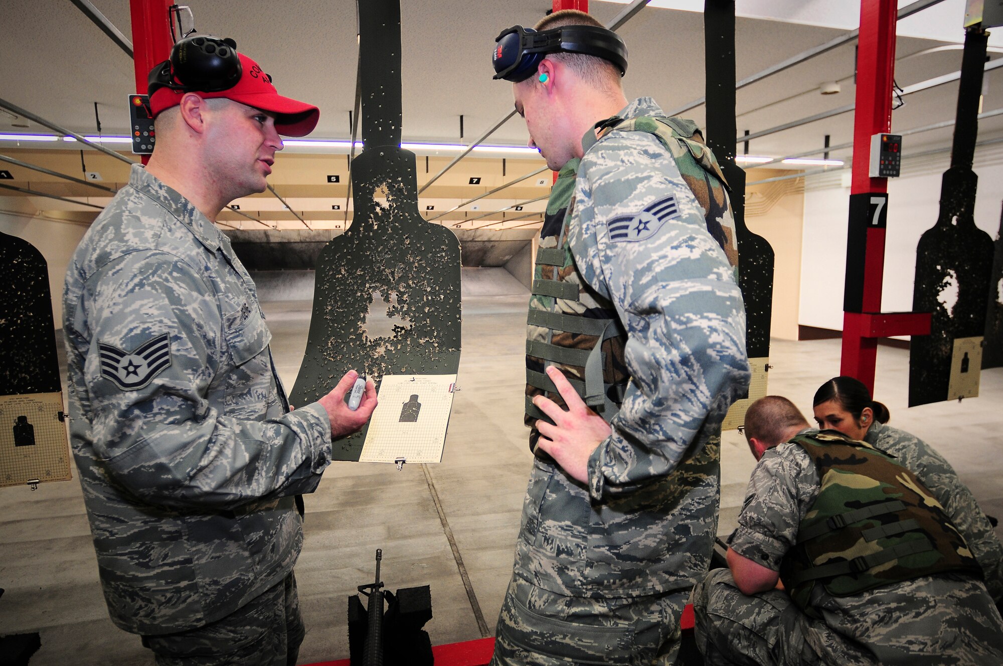 YOKOTA AIR BASE, Japan -- Staff Sgt. John Devine, Combat 374th Security Forces Squadron Combat Arms Instructor, critiques Senior Airman Eric Hunsaker 374th Force Support Squadron on his first practice round with the M-16 here Sept. 20. Airmen attend the weapons qualification course before they deploy or PCS. ( U.S. Air Force photo by Staff Sgt. Stacy Moless) 