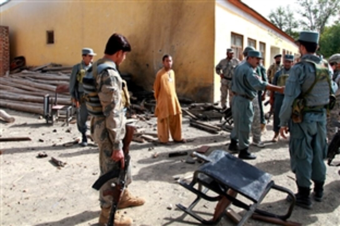 U.S. Army and Afghan soldiers, along with members of the Afghan National Police, investigate an improvised explosive device explosion that injured two local Afghans in Matun district, Khost province, Afghanistan, Sept. 18, 2010. The soldiers are assigned to the 101st Airborne Division's 3rd Brigade.