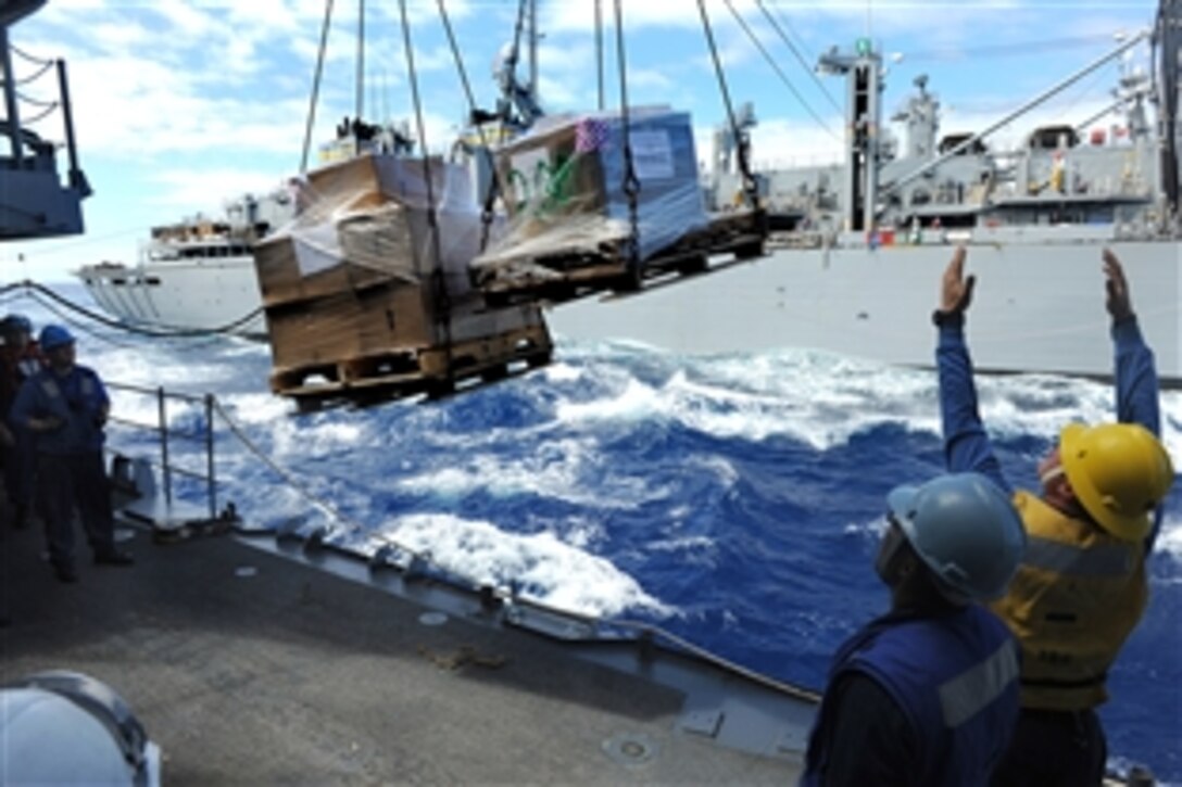 U.S. Navy Petty Officer 2nd Class Steve Rains, right, guides pallets onto the deck of the guided-missile cruiser USS Cape St. George during an underway replenishment with the USNS Rainier in the Pacific Ocean, Sept. 18, 2010. 