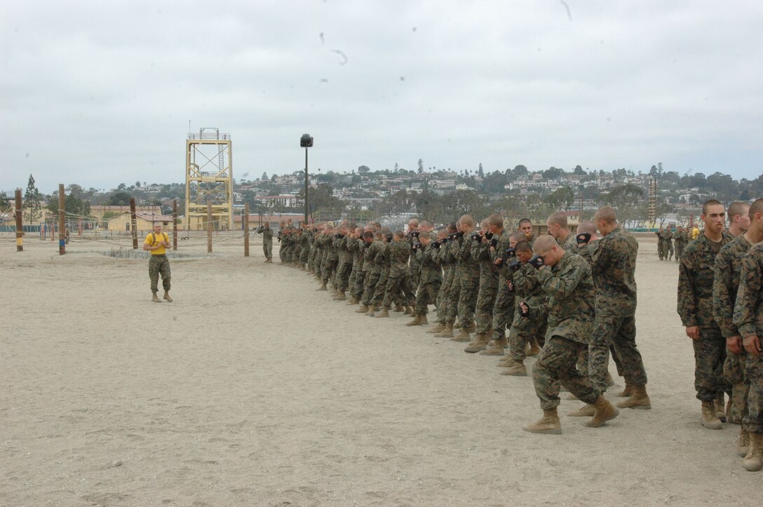 Company E recruits practice some Marine Corps Marital Arts moves while they await their turn in the pugil sticks ring here, Sept. 21.