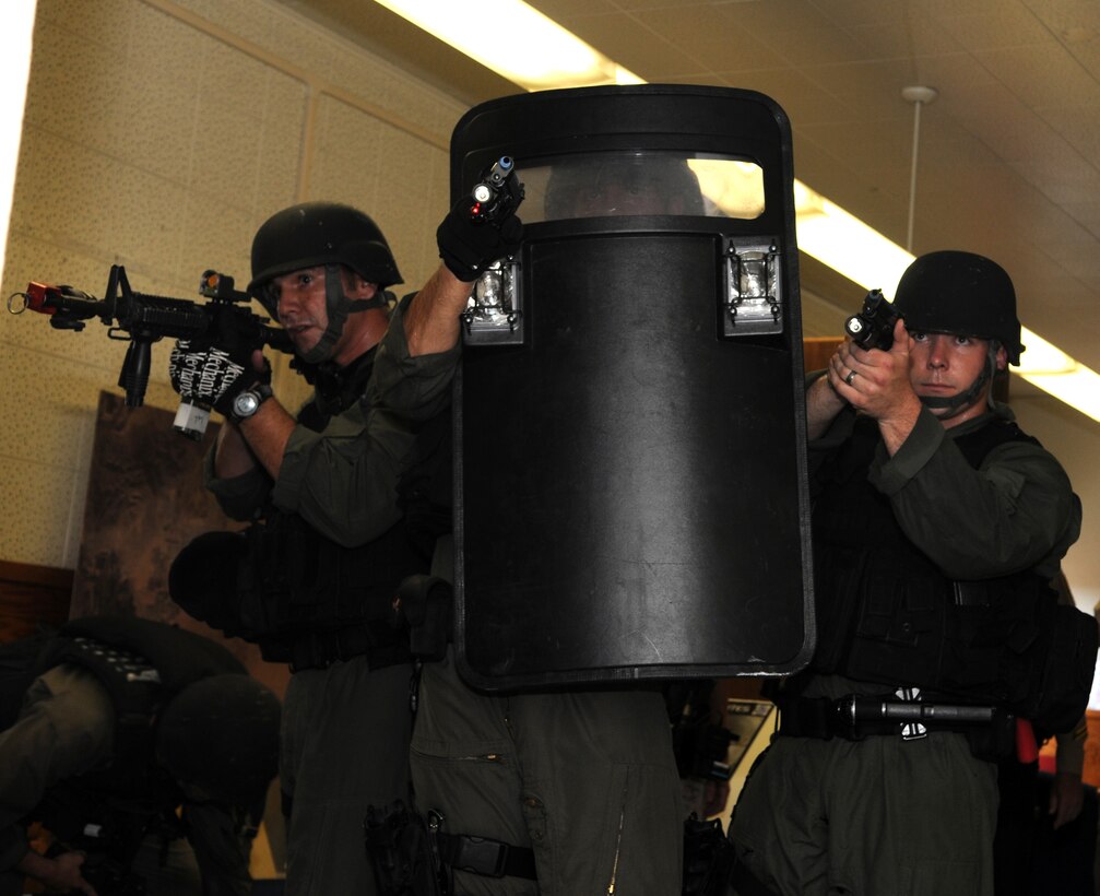 Military police special response team members at the Marine Corps Air Station in Yuma, Ariz., move through the hallways of the station’s headquarters building and sight in on a role-playing shooter who had taken several hostages in the building during Exercise Desert Fire, Sept. 21, 2010. The exercise was designed to assess the station’s response to an active shooter situation.
