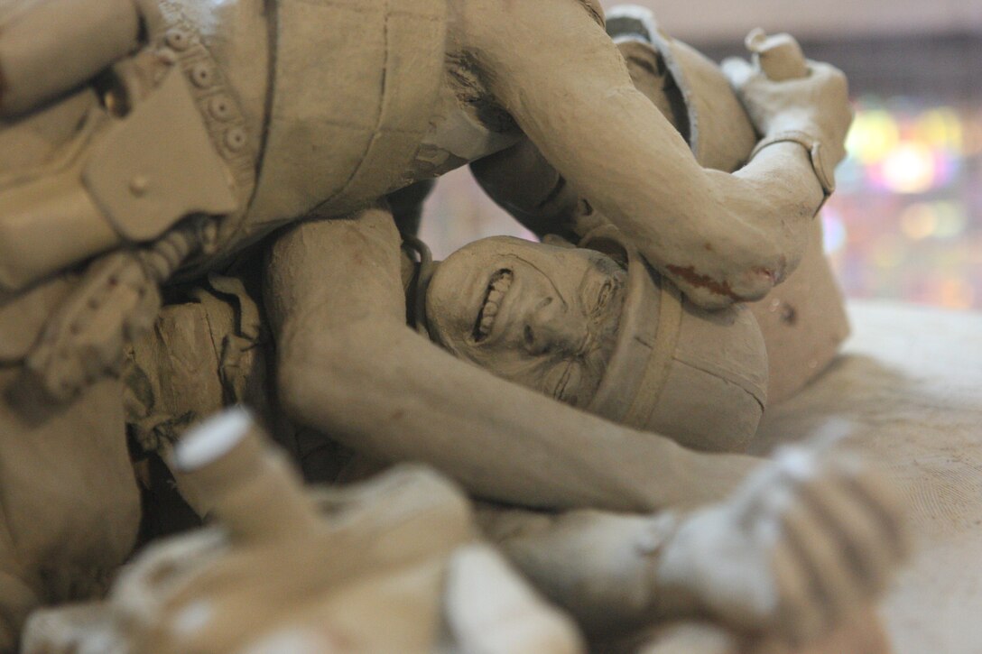 An injured Marine is shielded from imminent danger by a corpsmen in this clay replica of the planned life-sized bronze Corpsmen Memorial slated to be in the Lejeune Memorial Gardens in the next few years. Started in January 2008, the Corpsmen Memorial initiative is in honor of and recognition to all corpsmen who have served with the Marine Corps in the past, present and future.