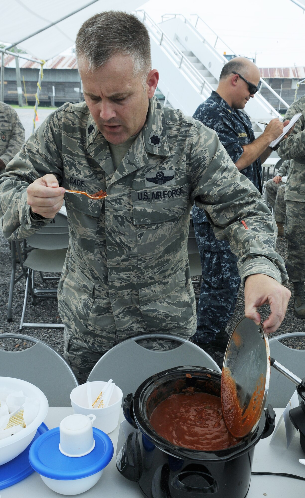 SOTO CANO AIR BASE, Honduras --  Working his way down the line, Lt. Col. David Cade, the 612th Air Base Squadron commander, takes a taste of chili during the Air Force Birthday Chili Cook-Off as Master Chief Shaun Schenkelberg, the finance NCOIC, takes notes here Sept. 17. Almost 10 teams from across Joint Task Force-Bravo entered chilis in the competition, but Tech. Sgt. Rashaun Monroe, of the 612th ABS fire department, took first place. (U.S. Air Force photo/Tech. Sgt. Benjamin Rojek)