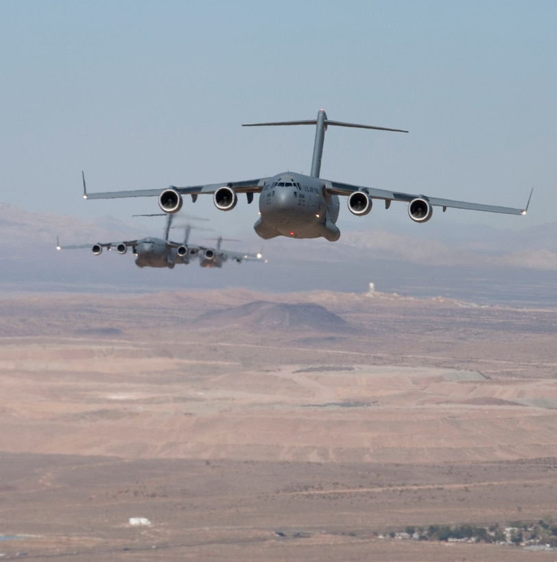 C-17s fly over Edwards Sept. 16. The 418th Flight Test Squadron conducted seven- ship flight testing to validate the formation flight system Sept. 7 to 17.  The testing culminated with a formation flight from Edwards to Charleston Air Force Base, S.C.(Air Force photo by Bobbi Zapka)  