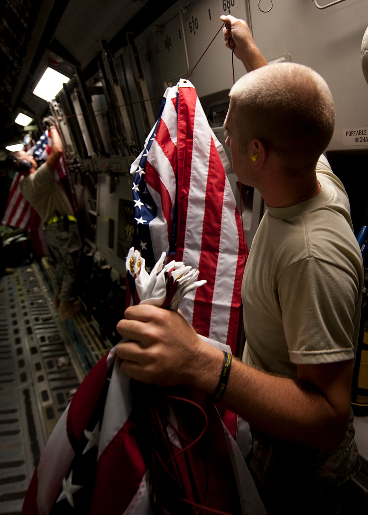 Airmen deployed to the Middle East assist in displaying more than 350 flags which were flown over the U.S. Central Command area of responsibility Sept. 11, 2010, in a C-17 Globemaster III by members of the 16th Airlift Squadron as a tribute and memorial to the lives lost in the 2001 attacks.  The flags were donated and flown for a variety of different individuals or organizations around the world such as fire departments, Veterans of Foreign Wars, the American Legion as well as for families and friends of those on base. (U.S. Air Force photo/Senior Airman Michael Means) 