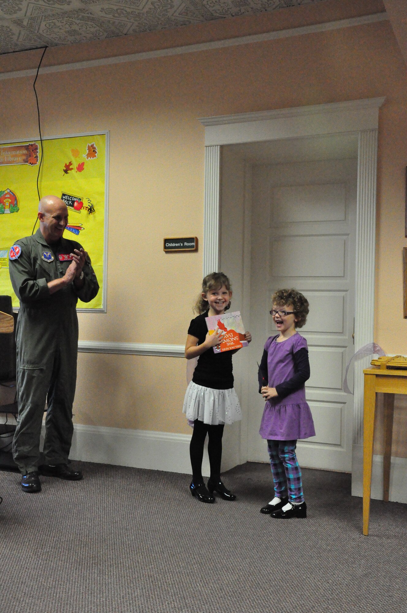Lieutenant Col. John Duda, 319th Missile Squadron and his daughters Cecilia and Sophia cut the ribbon to the Anne Duda Children’s Literacy Memorial room at the base library here Sept. 22. “We’re happy to share this with our Air Force family”, said Lt. Col. Duda. “We’re all separated from our biological families, so we need to rally around each other and become our own family here.” The improvements made in April to the library have seen increases in families using the libraries resources. An increase from one family coming to story time in March, to as many as 22 children in September were seen . (U.S. Air Force photo by Airman 1st Class Dan Gage)