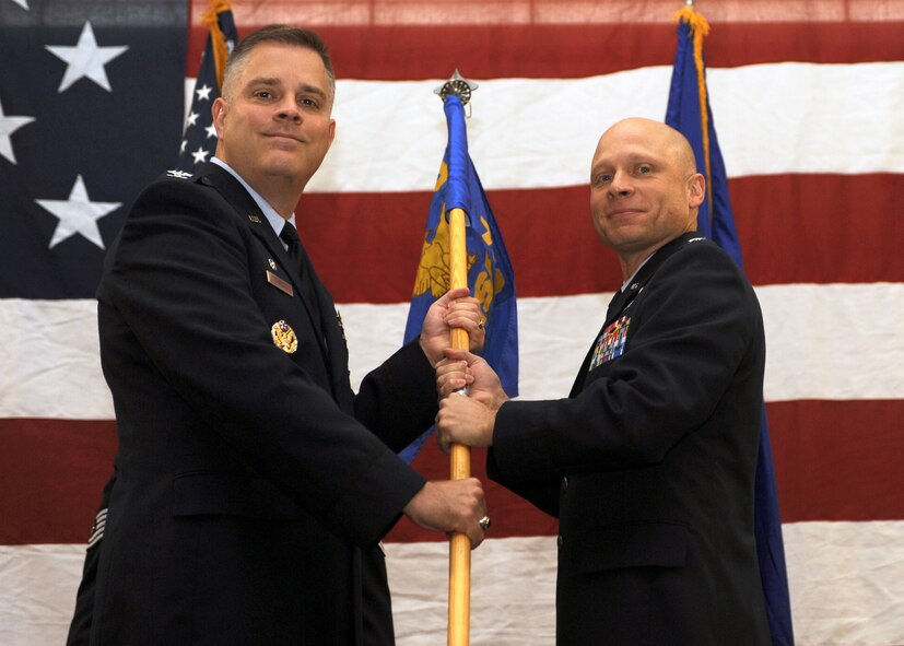 MINOT AIR FORCE BASE, N.D. -- Lt. Col. James C. Lowe assumes command of the 791st Missile Security Forces Squadron shown here taking the guidon from Col. James A Carroll, 91st Security Forces Group commander, Sept. 20. The 791st MSFS provides security forces for secure escort, unauthorized access denial and hostile recapture when needed for the 91st Missile Wing's 150 ICBMs, their launch facilities and 15 missile alert facilities spread across 8,500 square miles of Northwest North Dakota. The 91st MW is an integral member of Air Force Global Strike Command. (U.S. Air Force photo by Airman 1st Class Aaron-Forrest Wainwright)