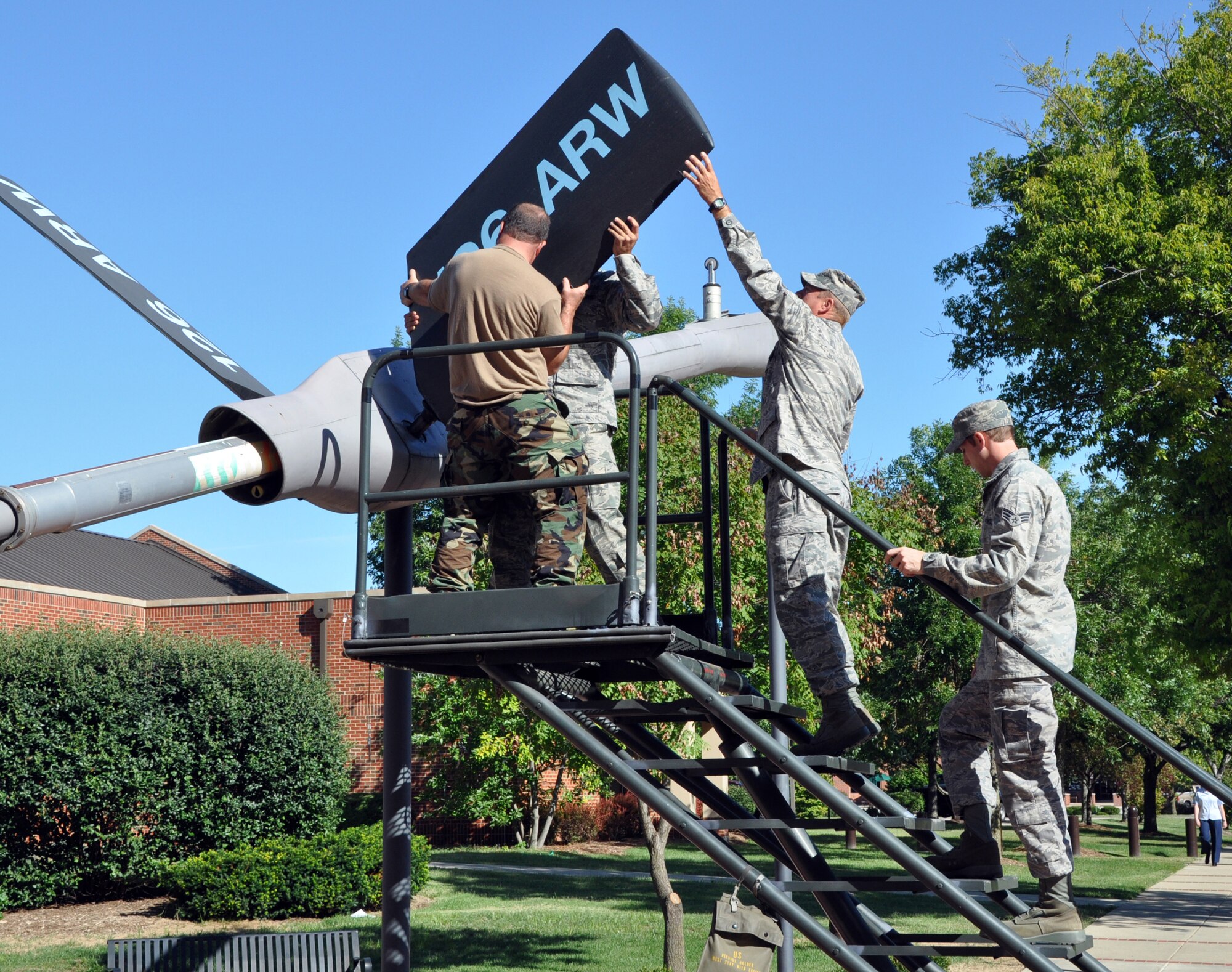 SCOTT AIR FORCE BASE, Ill. -- Members of Scott's 126th Maintenance Squadron disassemble the refueling boom in U.S. Transportation Command's Transportation Plaza Sept. 13. The squadron has volunteered to perform periodic upkeep on the boom. The volunteers are Master Sgt. Terry Szwet, Tech. Sgt. Joe McAndrews, Staff Sgt. Tipton Street and Senior Airman Jake Richards. (U.S. Air Force photo/Bob Fehringer)