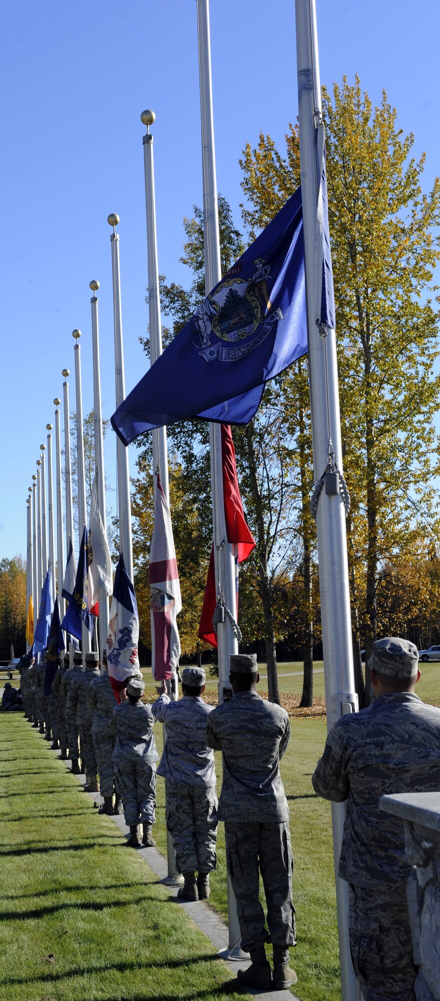 Members of the 354th Fighter Wing lower flags Sept. 17, 2010, Eielson Air Force Base, Alaska. The flags were lowered for the Prisoner of War/Missing in Action Ceremony. The ceremony commemorates troops captured and missing in war. (U.S. Air Force photo/Senior Airman Willard E. Grande II)