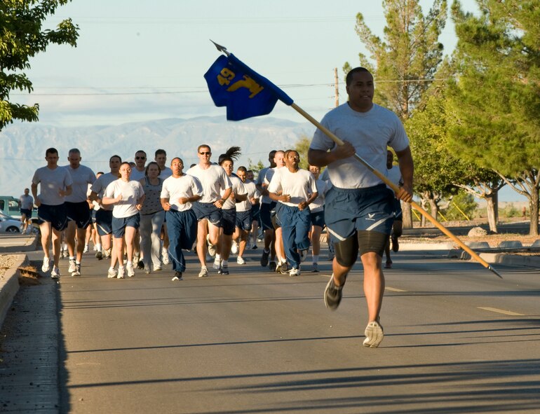 HOLLOMAN AIR FORCE BASE, N.M. -- Airman 1st Class Siuta Ika, 49th Wing Public Affairs, leads the way with the 49th WG guidon during the Wing Run on Sports Day Sept. 17, 2010. Approximately 2,000 Team Holloman members from across the wing participated in the run, which kicked off the day of sporting events and friendly competition. (U.S. Air Force photo by Tech. Sgt. Alan Port / Released)