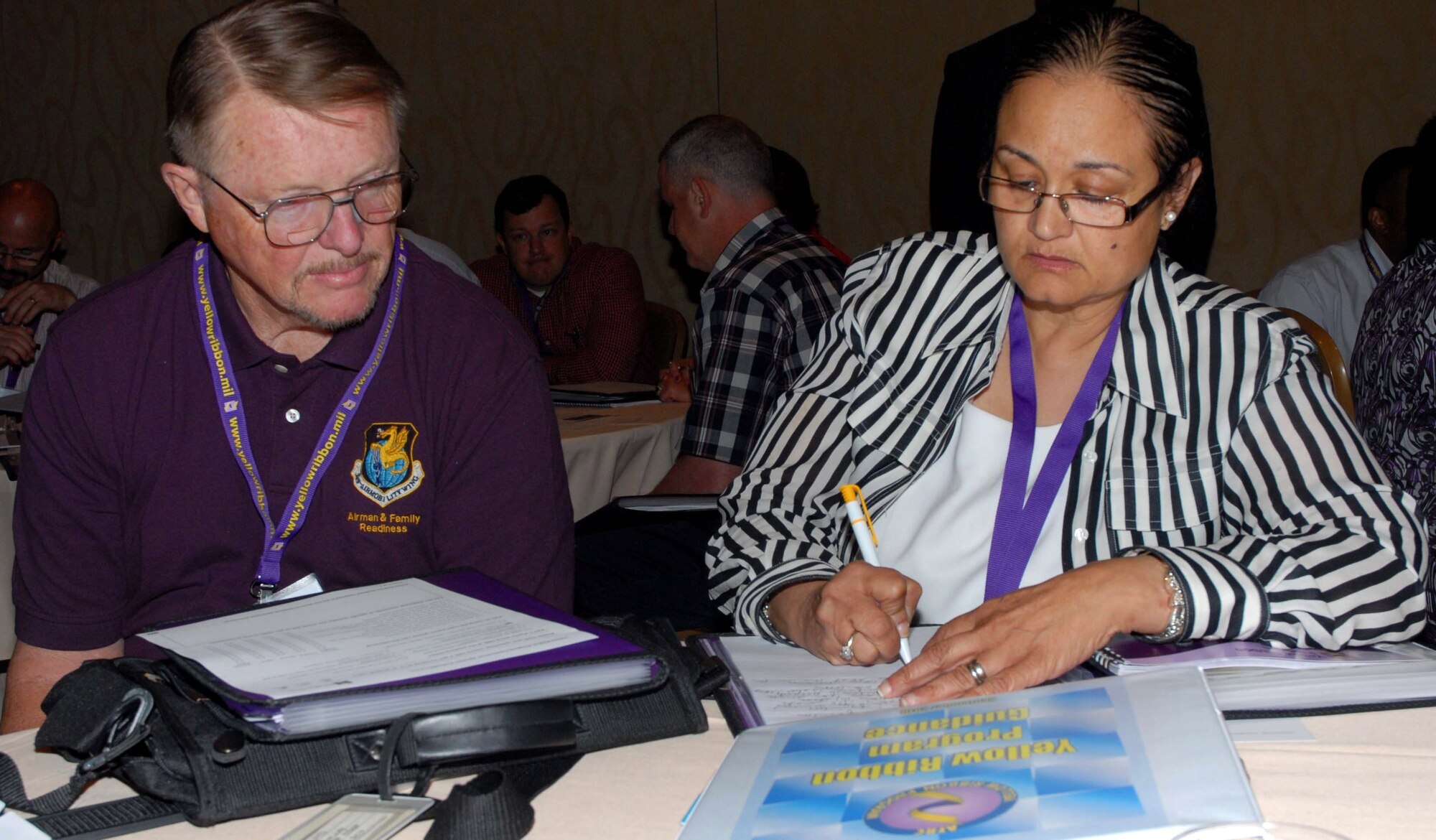 Jack Watts and Master Sgt. Pamela Silas, both of Travis AFB, write down notes during one of the breakout sessions at a Yellow Ribbon Program conference held in Orlando, Fla. The conference provided an opportunity for those who work with Yellow Ribbon to learn how to improve the program. (U.S. Air Force photo by Tech. Sgt. Kenneth McCann)
