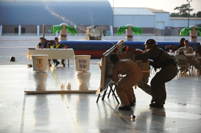 Members of the 437th Airlift Wing engage in a water gun fight during the combat dining out on Joint Base Charleston, S.C., Sept. 17, 2010. Two members provided cover with a folding table while the other took aim against their adversaries on the opposite side of the hangar. (U.S. Air Force photo/James M. Bowman)(Released)