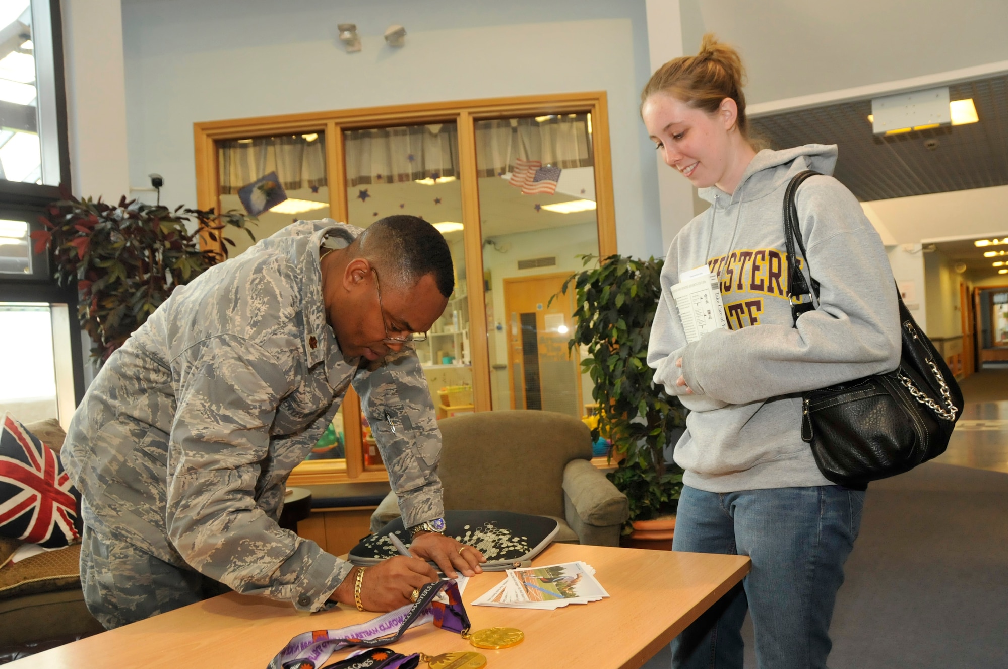 Maj. George Onyenyeonwu,48th MDG group practice manager, and 1998 Nike Masters Games 100m and 200m world champion, gives Rebekah Blakeman, wife of Airman 1st Class Andrew Blakeman, 48th Civil Engineer Squadron engineer apprentice, an autographed photo at the ‘care for the care giver training’ at CDC West Sept. 18. Maj. Onyenyeonwu helped out at the back safety station which was ran by the 48th Medical Operations Squadron Physical and Occupational Therapy clinic and briefed on proper lifting and posture. (U.S. Air Force photo/Airman 1st Class Eboni Knox) 