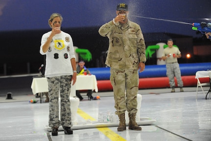 437th Operations Group Commander Col. Robert Holba gets a little help quenching his thirst while drinking from the grog bowl with his wife Jane during the combat dining out on Joint Base Charleston, S.C., Sept. 17, 2010. The grog bowls were porcelain toilets converted into punch bowls. Typically, there are two grog bowls containing mysterious concoctions - one with spirits, the other not. Throughout the evening, some members are encouraged to have a drink from the bowl whenever an infraction to protocol is made, all in good fun. The tradition of combat dining outs provide service members a unique, off-duty opportunity to unwind and enjoy an evening with their spouses and friends. The dining out has rules, etiquette and procedures, with a special emphasis on Airmen having fun. (U.S. Air Force photo/James M. Bowman)(Released)