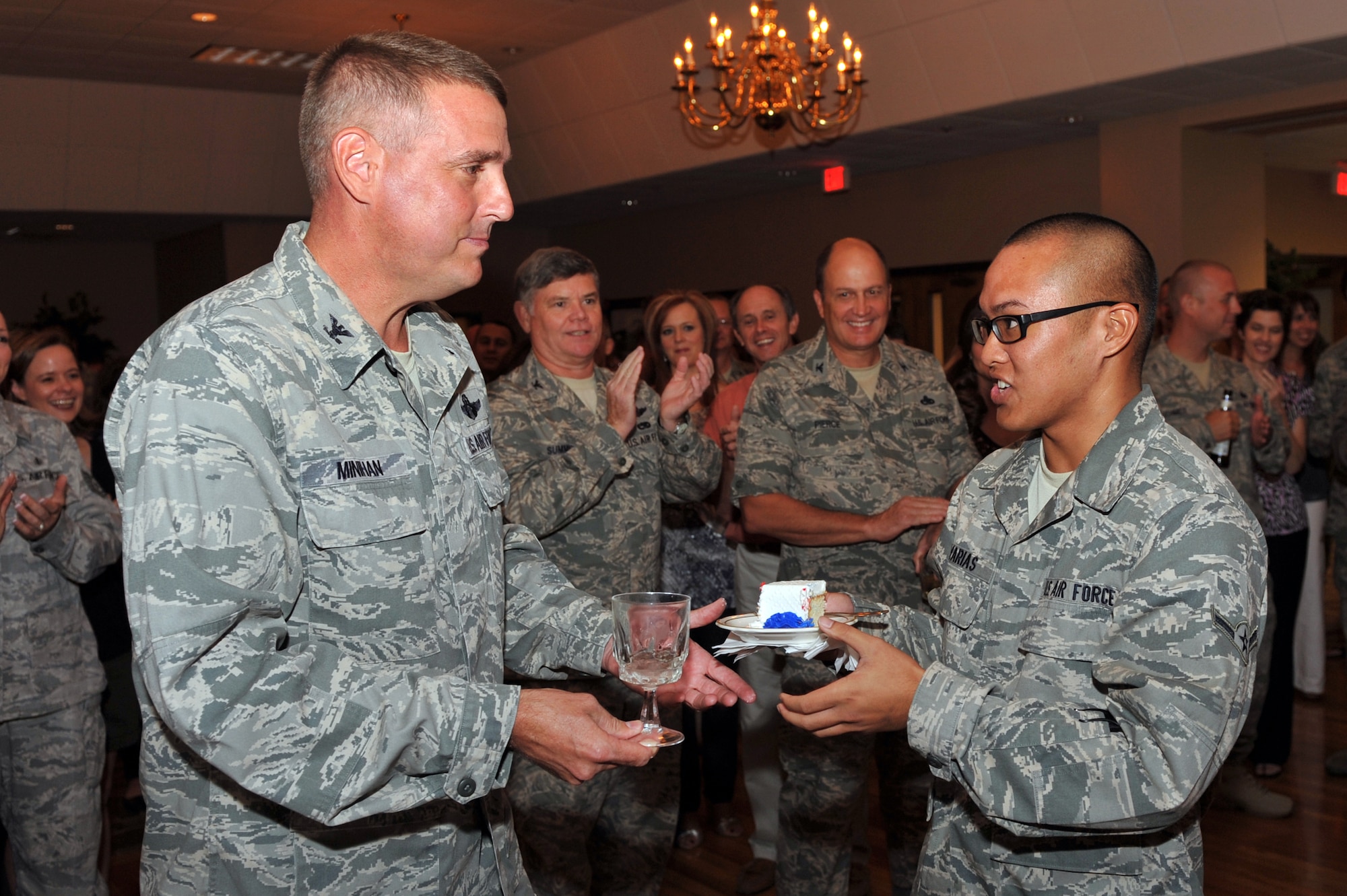 Col. Mike Minihan, 19th Airlift Wing commander, hands the first slice of the Air Force birthday cake to Airman Andrew Lavarias, 62nd Airlift Squadron aviation resource manager, Sept. 18. Airman Lavarias received the slice of cake as the youngest Airman in attendance during the ceremony. (U.S. Air Force photo by Staff Sgt. Chris Willis)