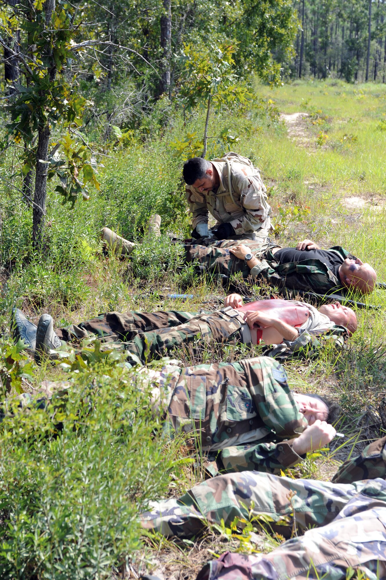 U.S. Air Force Tech. Sgt. Marc Marrero, 1st Special Operations Support Squadron, bandages a wound on a simulated victim while others wait for triage during a medical exercise on the Eglin range, Fla., Sept. 14, 2010. The purpose of the exercise is to prepare and train medics for a deployed environment. (DoD photo by U.S. Air Force Airman 1st Class Caitlin O'Neil-McKeown/RELEASED)