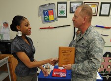 Aepril Smith receives the Air Force Services Youth of the Year award for 2010 from 628th Mission Support Group Commander Col. Ben Wham at the Youth Programs Center Sept. 17, 2010, on Joint Base Charleston, S.C. The Youth of the Year program recognizes young people for their contribution to their families, youth programs, schools and communities. Aepril is a high school senior at Wando High School and plans to attend Duke University upon graduation. (U.S. Air Force photo/Senior Airman Timothy Taylor)