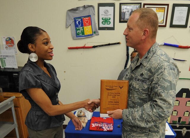 Aepril Smith receives the Air Force Services Youth of the Year award for 2010 from 628th Mission Support Group Commander Col. Ben Wham at the Youth Programs Center Sept. 17, 2010, on Joint Base Charleston, S.C. The Youth of the Year program recognizes young people for their contribution to their families, youth programs, schools and communities. Aepril is a high school senior at Wando High School and plans to attend Duke University upon graduation. (U.S. Air Force photo/Senior Airman Timothy Taylor)