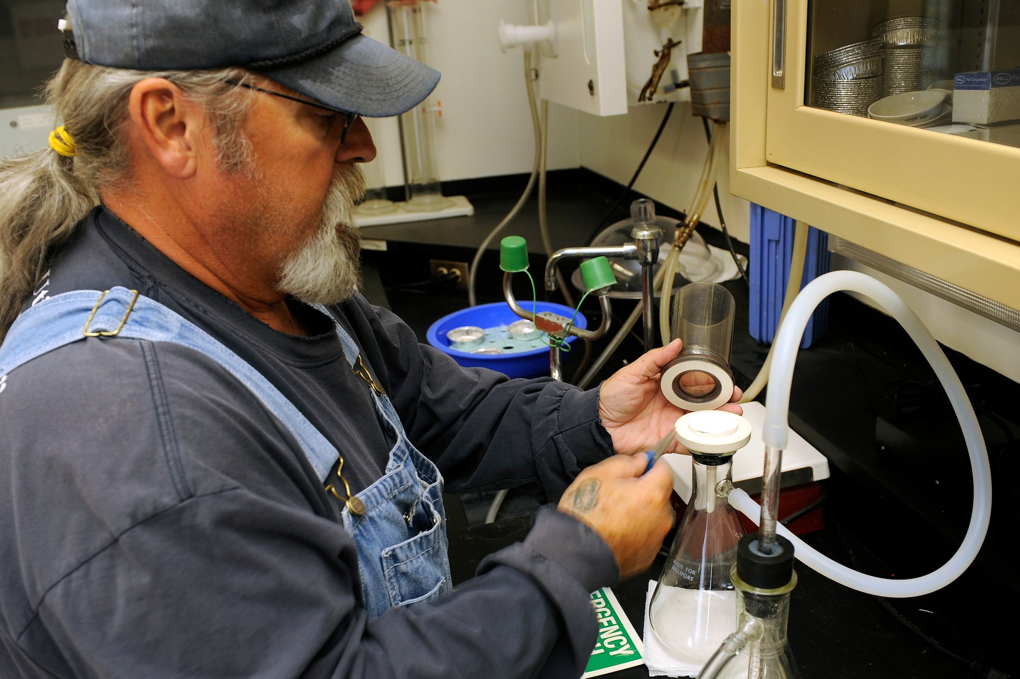 ELLSWORTH AIR FORCE BASE, S.D. - Chuck Hand, Optech Monette lab supervisor, places a glass fiber filter into a dual suction decanter at the Ellsworth waste water treatment facility, Sept. 15.  The filter is used to test treated waste water for total suspended solid amounts. (U.S. Air Force photo/Staff Sgt. Marc I. Lane)