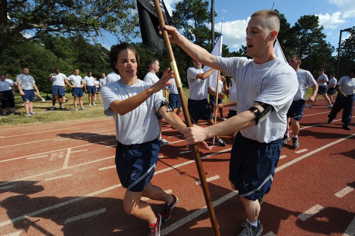U.S. Air Force Senior Airman Jessica Dial takes the Prisoner of War/Missing in Action flag from Staff Sgt. David Wright on Joint Base Charleston, S.C., Sept. 16, 2010. The Airmen were participants in a 24-hour relay run to keep the POW/MIA flag in continuous motion. Airman Dial is an aerospace propulsion journeyman with the 437th Aircraft Maintenance Squadron and Sergeant Wright is a cyber surety journeyman with the 628th Communications Squadron. (U.S. Air Force photo/James M. Bowman)(Released)