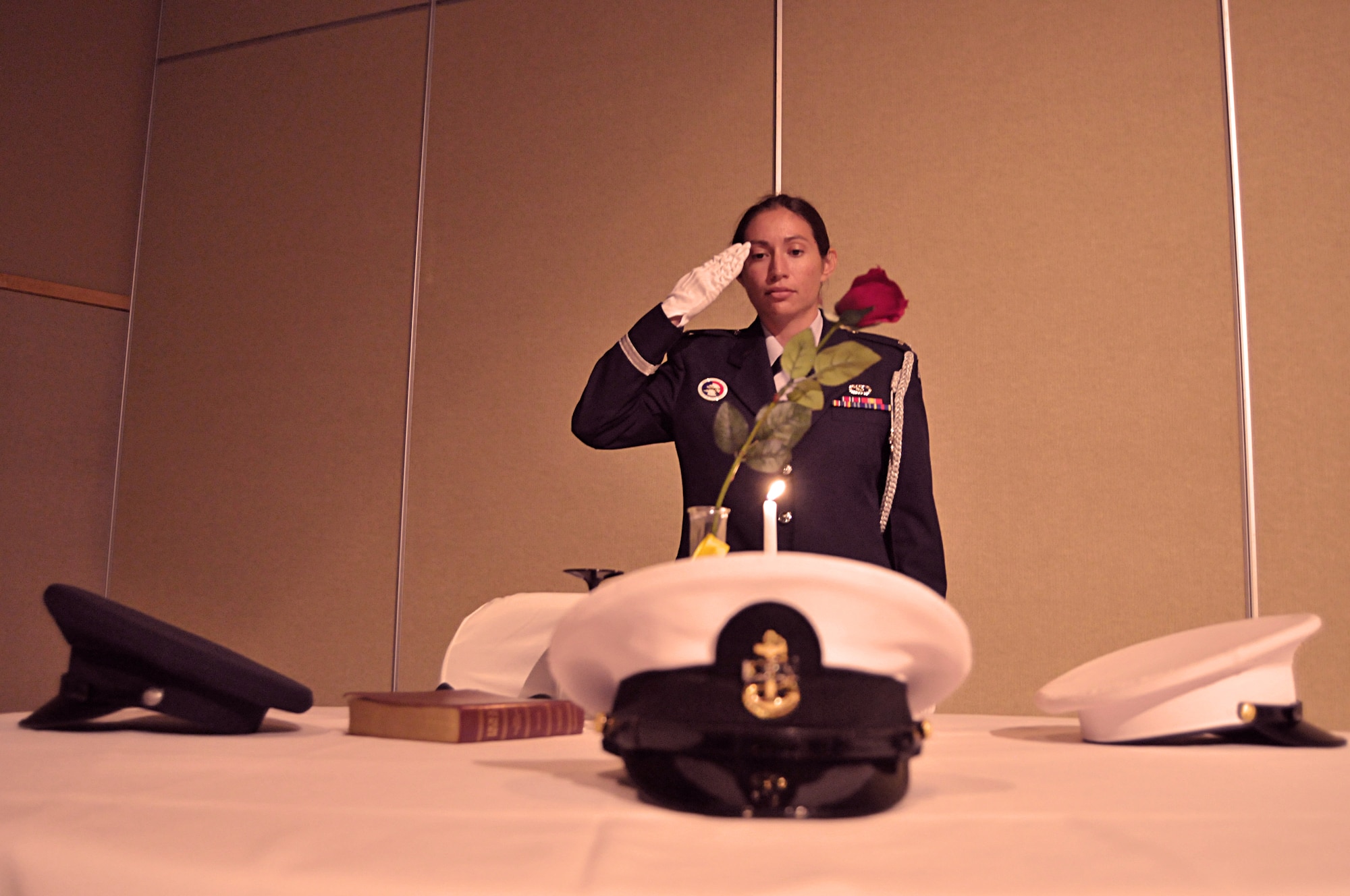 GOODFELLOW AIR FORCE BASE, Texas – Honor Guard member, 1st Lt. Melissa Collins, 17th Civil Engineer Squadron, pays respect to the POW/MIA Table of Honor after lighting the candle, during the 63rd Annual Air Force Ball Sept. 17 at the McNease Convention Center. The POW/MIA Table of Honor symbolizes members of each branch of the military who are still missing. (U.S. Air Force photo/ Senior Airman Tong Duong)