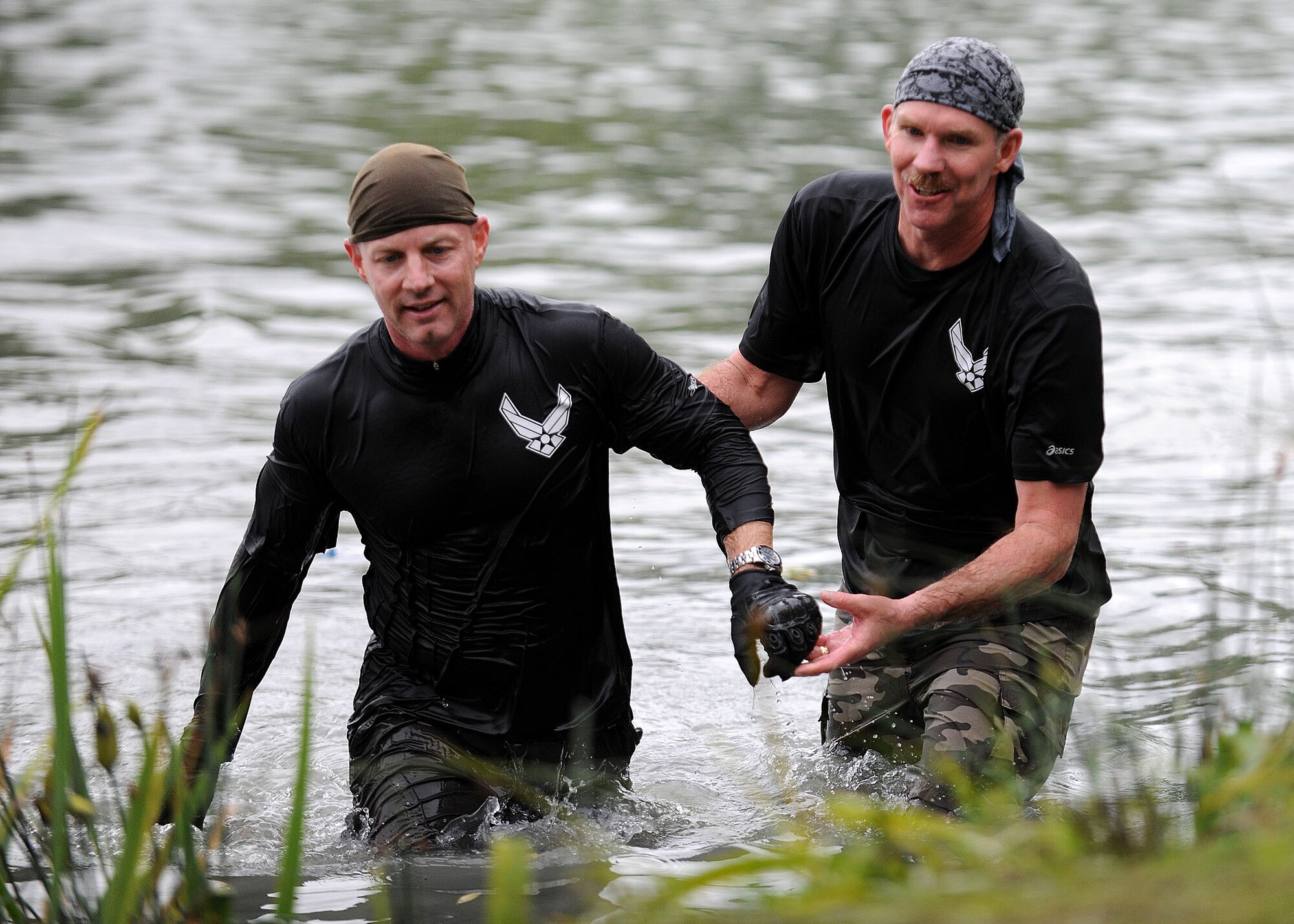 CAMBRIDGE, England -- Col. Joseph DeMarco, 100th Operations Group commander (left), completes the water obstacle, while Chief Master Sgt. Christopher Powell, 100th Air Refueling Wing command chief, helps him up during the Spartan Race here Sept. 19. This 5K race forces participants to tackle 12 obstacles in order to complete the event. This is the first time the Spartan Race has been held outside of the United States, and event planners hope it will return next year. (U.S. Air Force photo/Staff Sgt. Jerry Fleshman)