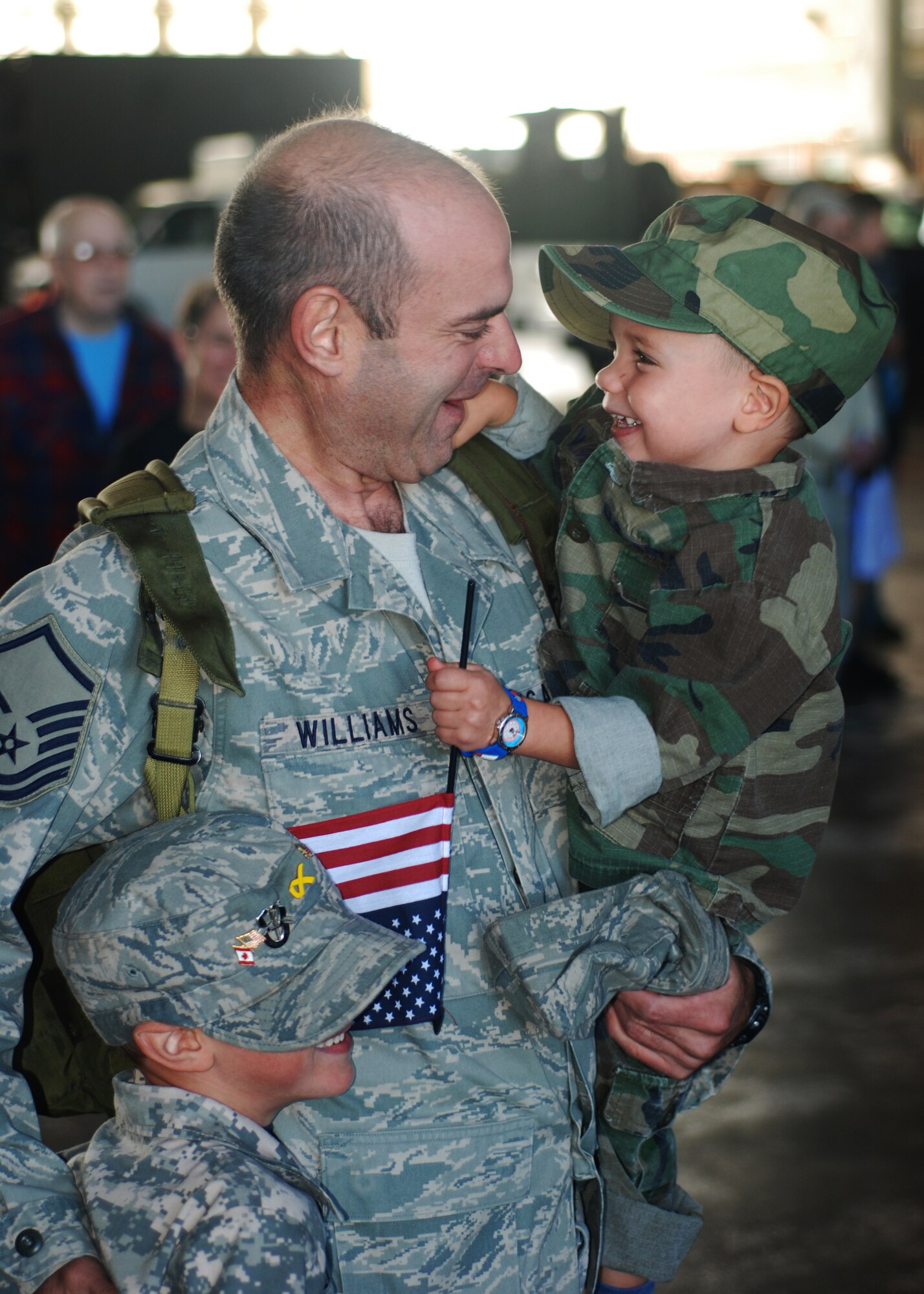 Master Sgt. Thomas Williams, 58th Aerial Port Squadron, sees his sons for the first time in four months.  Sergeant Williams returned from his deployment to Kandahar Airfield Sept. 21 and was greeted by family, friends and fellow Airmen at the Aerial Port Hangar.  