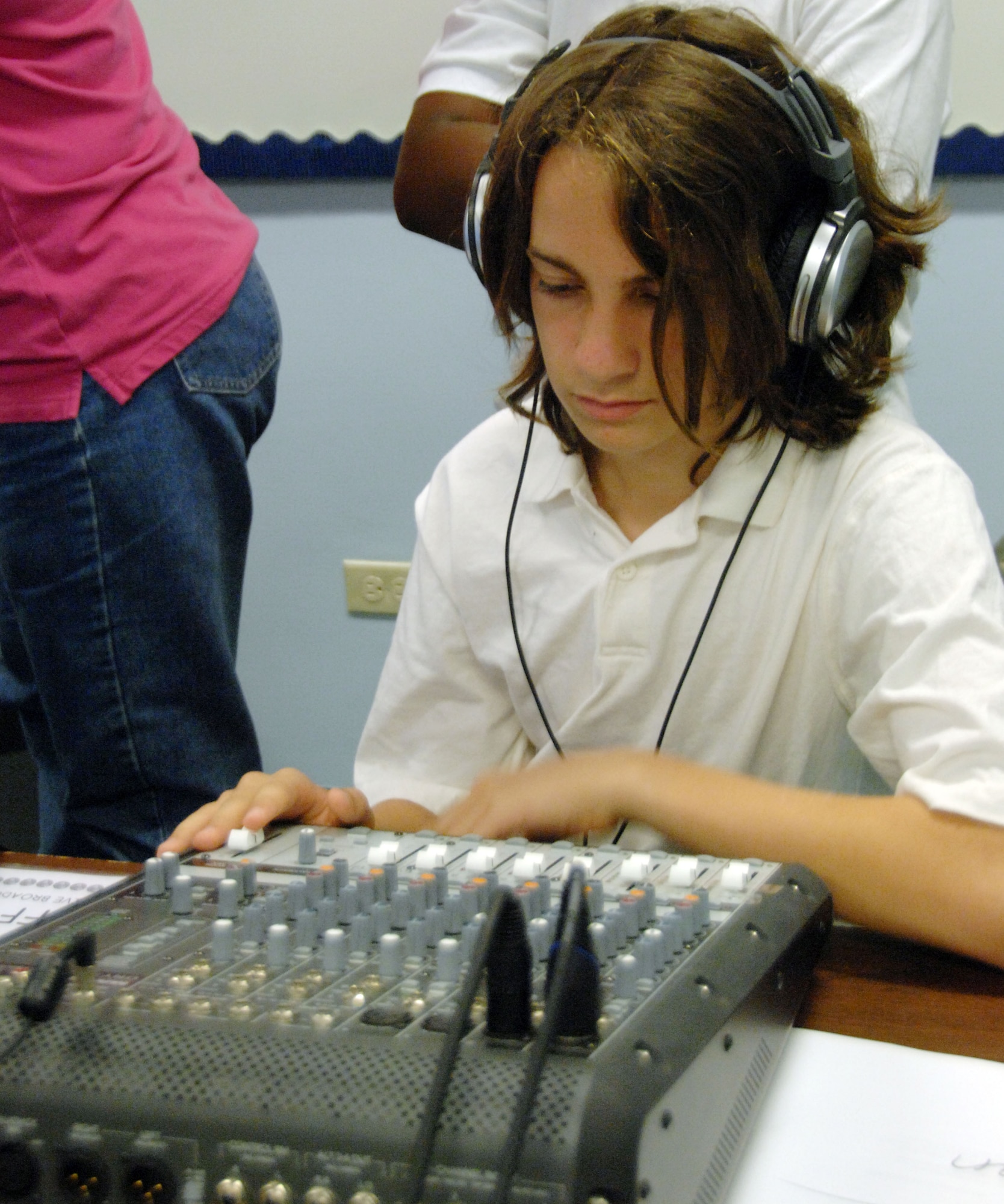 Tristyn Christenson, a 7th grade student at Andersen Middle School, trains on the sound board to become part of the KAMS-TV crew. KAMS-TV broadcasts live throughout AMS each morning providing the student body with news, sports updates and important announcements. (U.S. Air Force photo by Airman Whitney Amstutz)