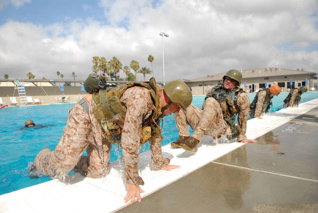 Marine Corps Instructor of Water Survival students climb out of the Combat Training Tank after performing drills at Marine Corps Air Station Miramar, Calif., Sept.22.