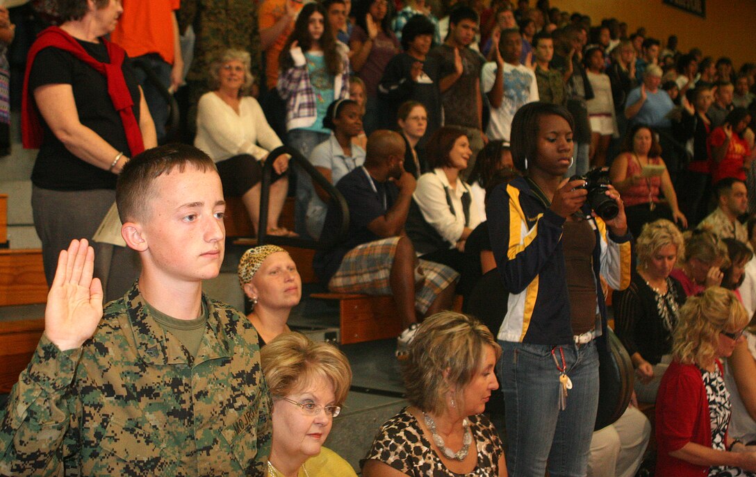 Students from Camp Lejeune High School respond to a question posed by the Commanding Officer of 8th Marine Regiment, Col. Eric M. Smith, during the regiments official adoption of the high school through the Department of Defense Education Activity Adopt a School program.  The question asked of the students concerned how many of them have parents currently serving abroad or are preparing to leave.