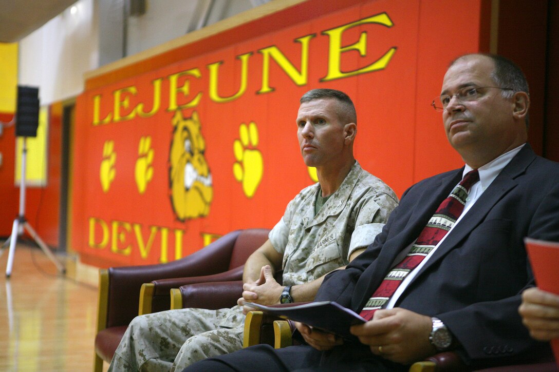 Col. Eric M. Smith, the commanding officer of 8th Marine Regiment, and Eric Steimel, the principal of Camp Lejeune High School, look on as the Adopt a School proclamation is read to the student body.  Marines from the regiment will continue community service projects around the school as well as assist with tutoring and mentoring students.