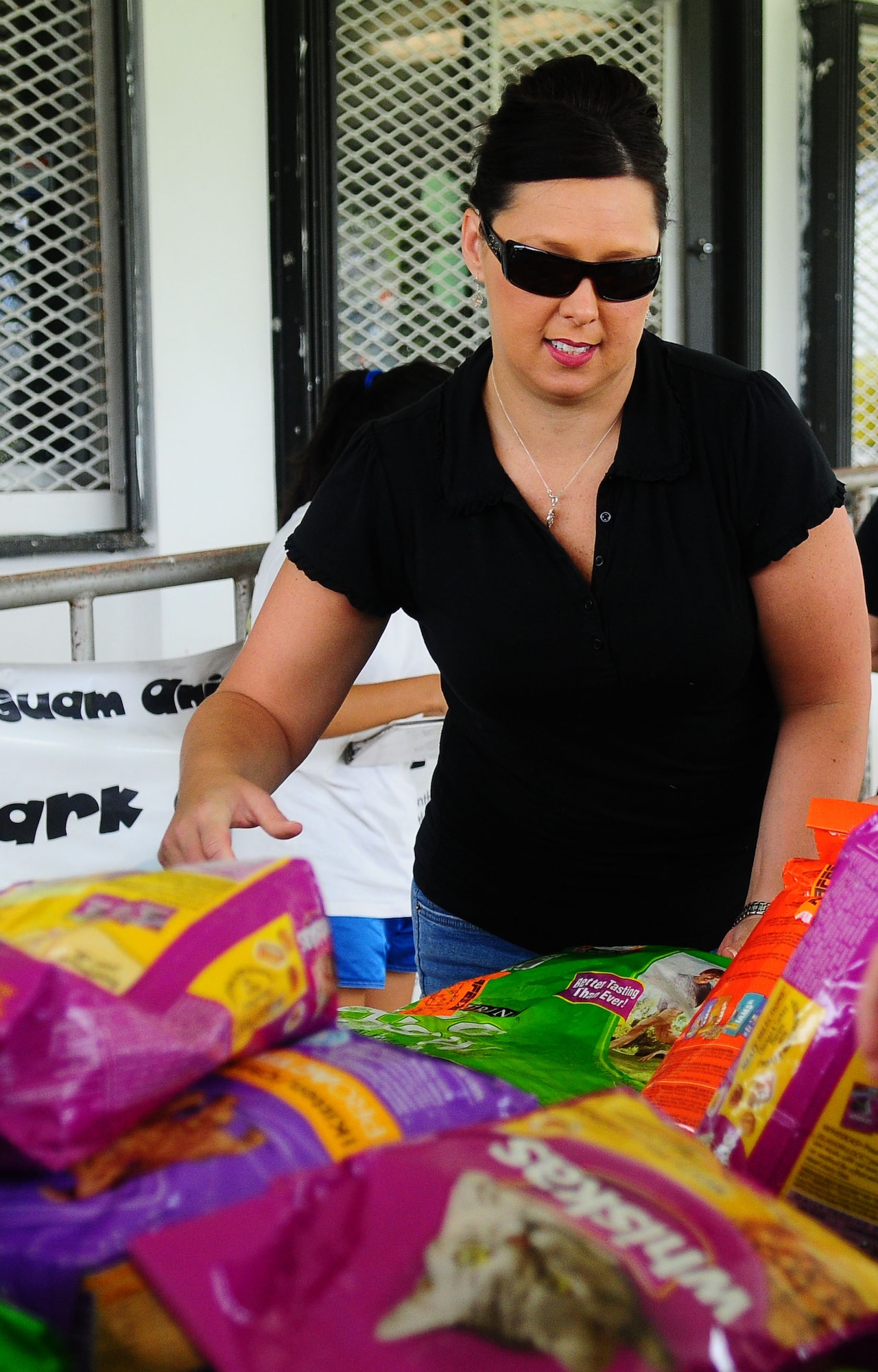 Debra Papalia, President of the Enlisted Spouse’s Club, unloads bags of dog and cat food at the Guam Animals In Need shelter in Yigo Sept. 21. The club hosted a bake sale to help replenish the shelter’s depleted supply after a robbery in early Sept. (U.S. Air Force photo by Airman Whitney Amstutz)