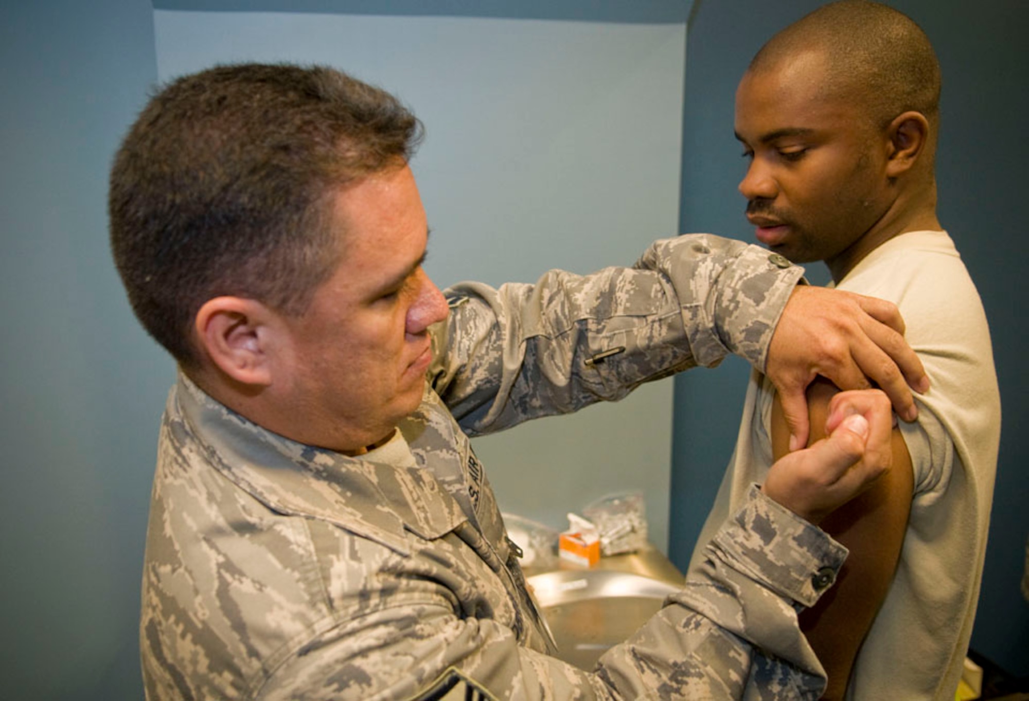 Master Sgt. Louis Lobrigo, 35th Surgical Operations Squadron, administers a vaccine to Staff Sgt. Travis Deramous, 35th Aircraft Maintenance Squadron, during a Misawa Air Base, Japan, personnel deployment function line, Sept. 23, 2010. Sergeant Deramous processed the PDF line, which served as a one-stop-shop for Airmen facilitating their deployment out-processing requirements. (U.S. Air Force photo by Senior Airman Jessica Lockoski/Released)