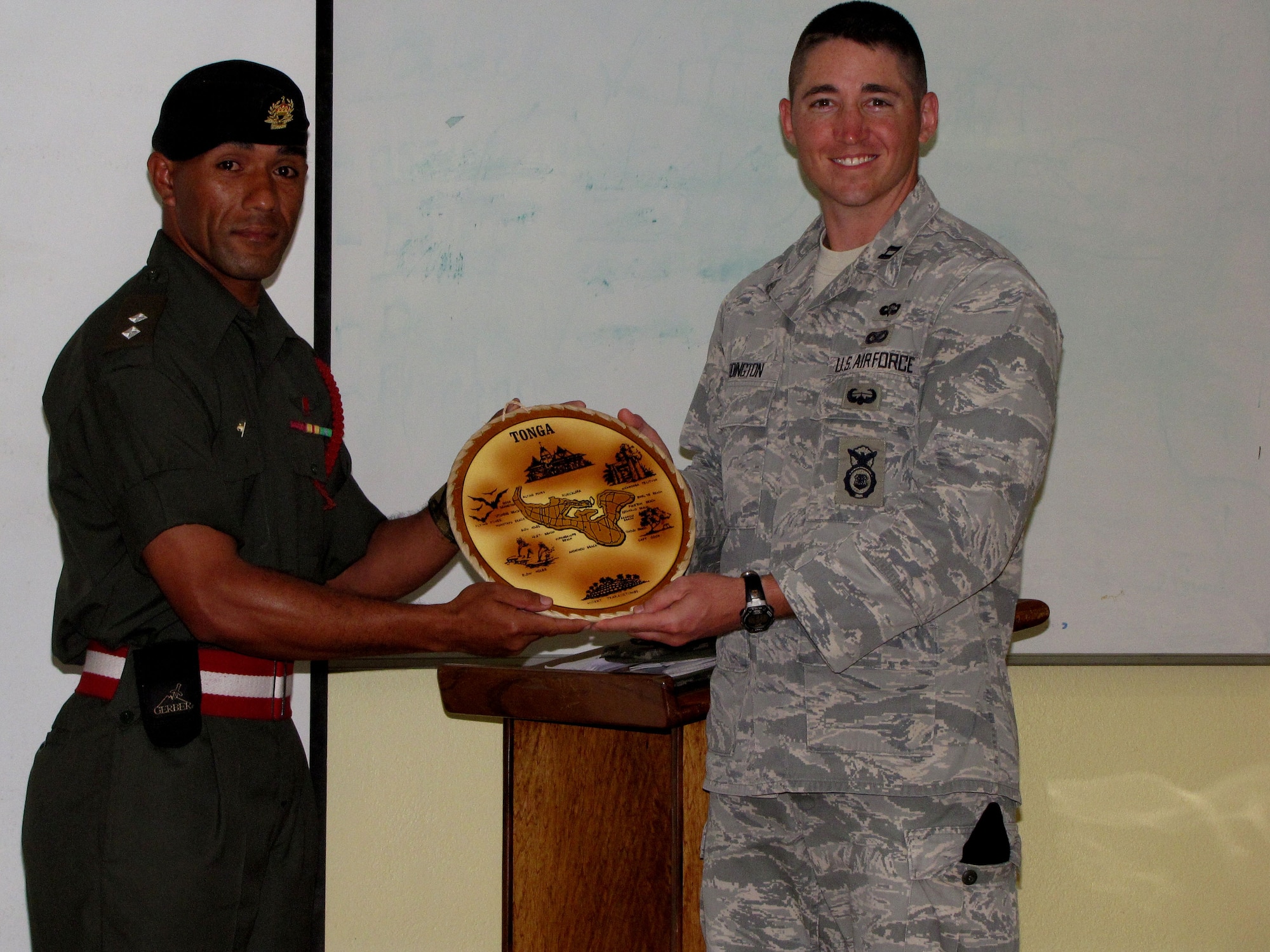 1st Lt.  Toma Tuitayaki, from the Tongan Defense Forces, presents U.S. Air Force Captain Stephen Addington, a cadre instructor from the 736th Security Forces Squadron’s Commando Warrior Regional Training Center at Andersen Air Force, Guam, with a token of appreciation plaque during a U.S. and Tongan Subject-Matter Expert Exchange in Nuku’alofa, Kingdom of Tonga, on Sept. 18, 2010.  The SMEE, which focused on tactical-team combat maneuvers, allowed U.S. and Tongan forces to share force protection and security operations information and understanding among attendees. (U.S. Air Force photo/ Francis Deniz) 