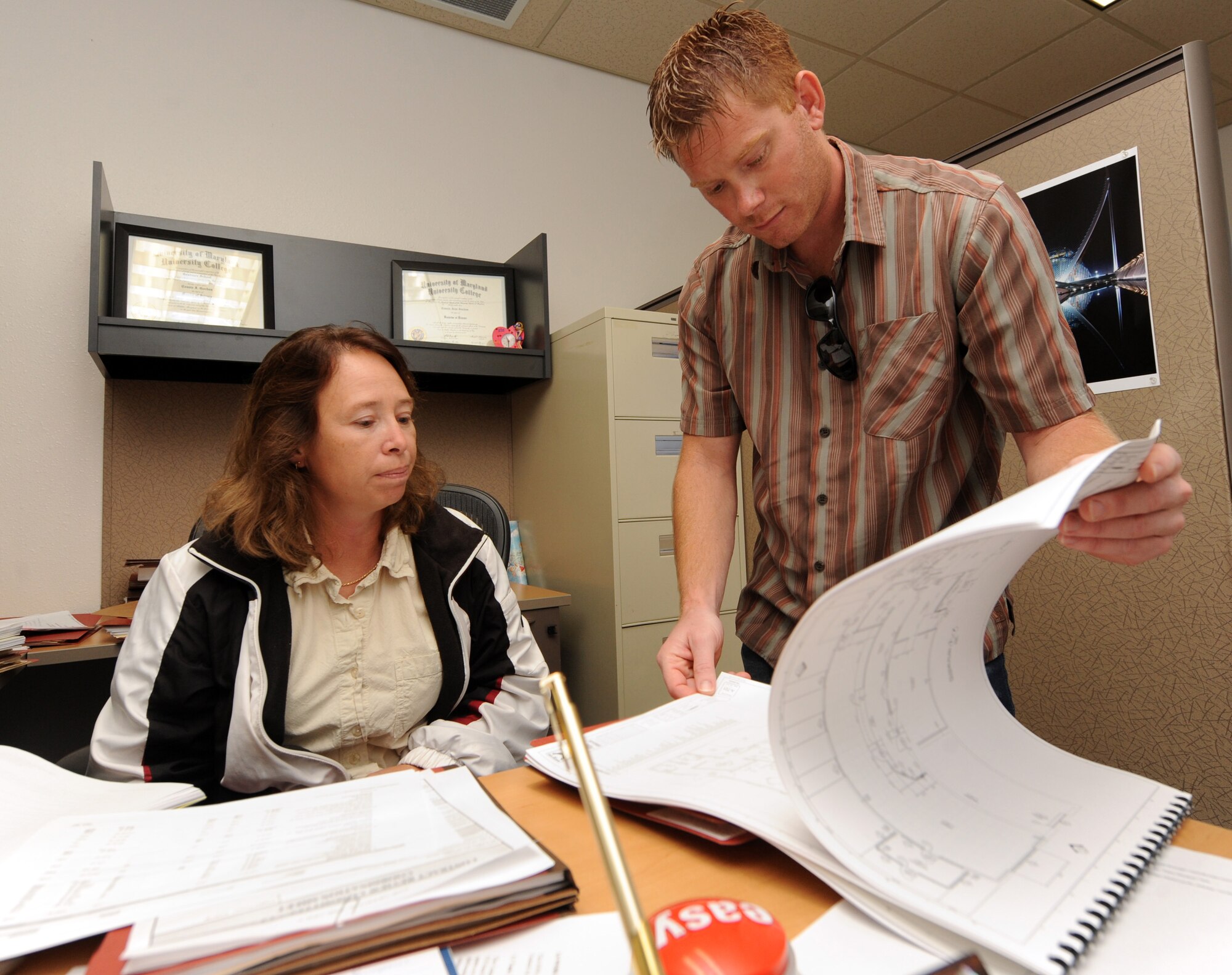 MOUNTAIN HOME AIR FORCE BASE, Idaho -- Connie Gordon, 366th Contracting Squadron architect and engineer contract specialist, reviews building plans with Jason Darst, 366th Civil Engineer Squadron, as the CONS works to complete end of year contracts Sept 10. The Contracting Squadron provides business advice and an overall base acquisition program to support the 366th Fighter Wing’s contracting needs. (U.S. Air Force photo by Senior Airman Debbie Lockhart)